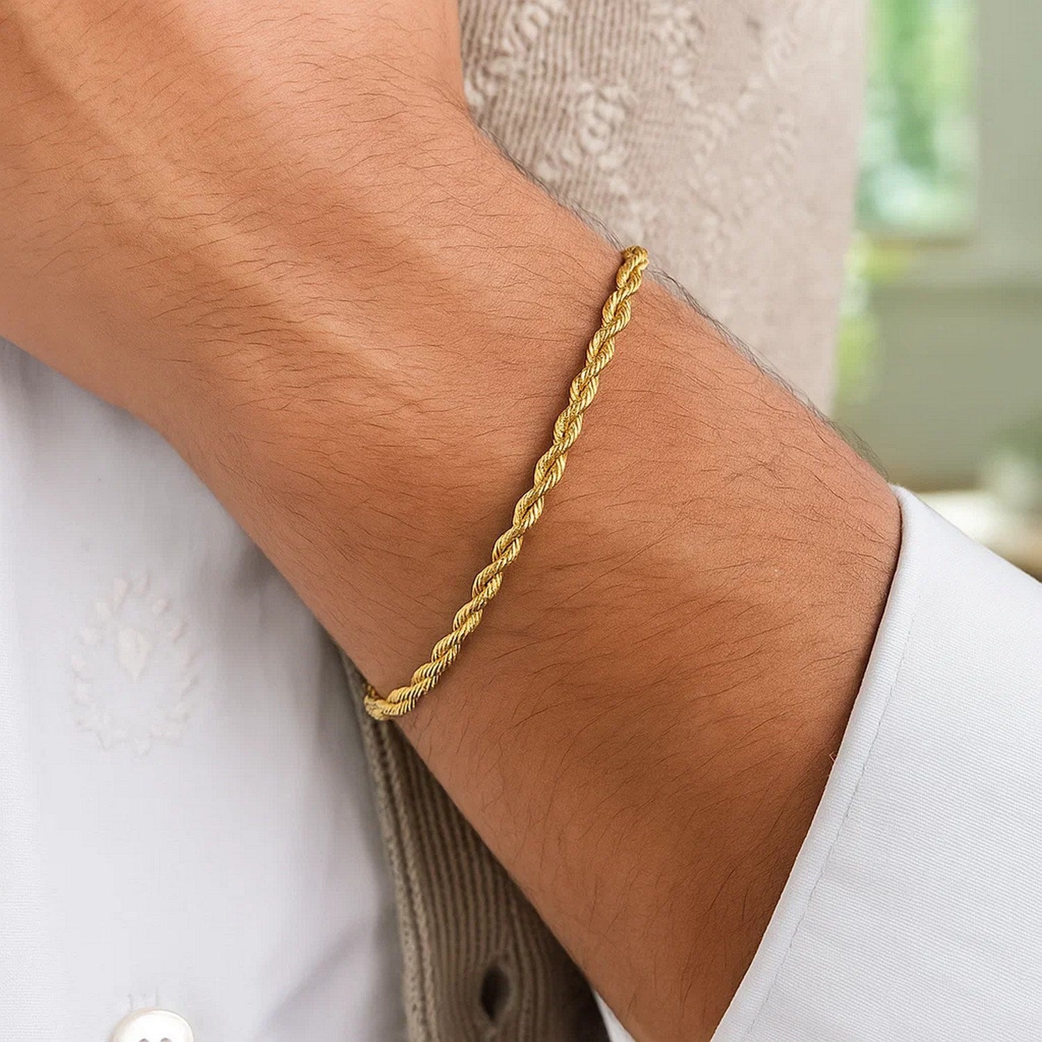 A 14k yellow gold rope chain bracelet on a person's wrist.