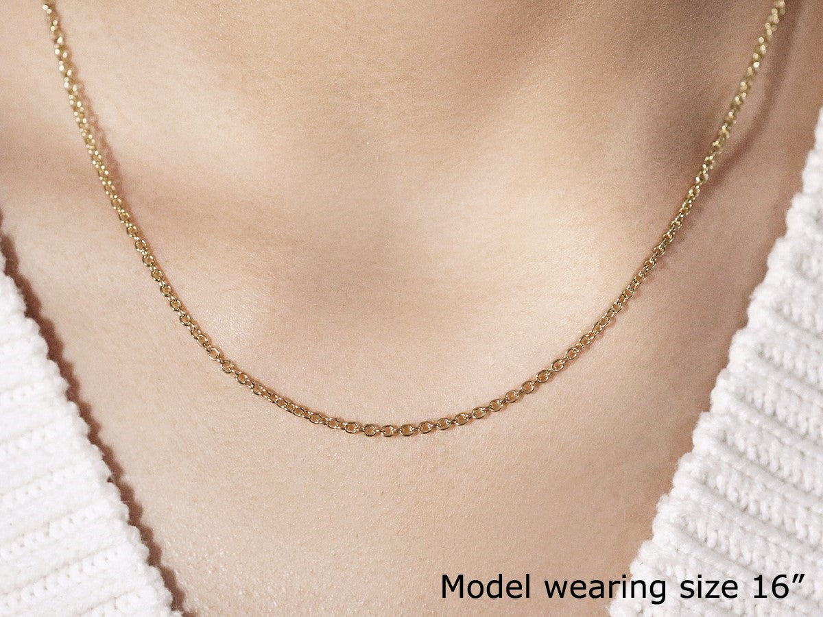 A 14k yellow gold round cable link chain, 1.9mm wide, worn by a model.