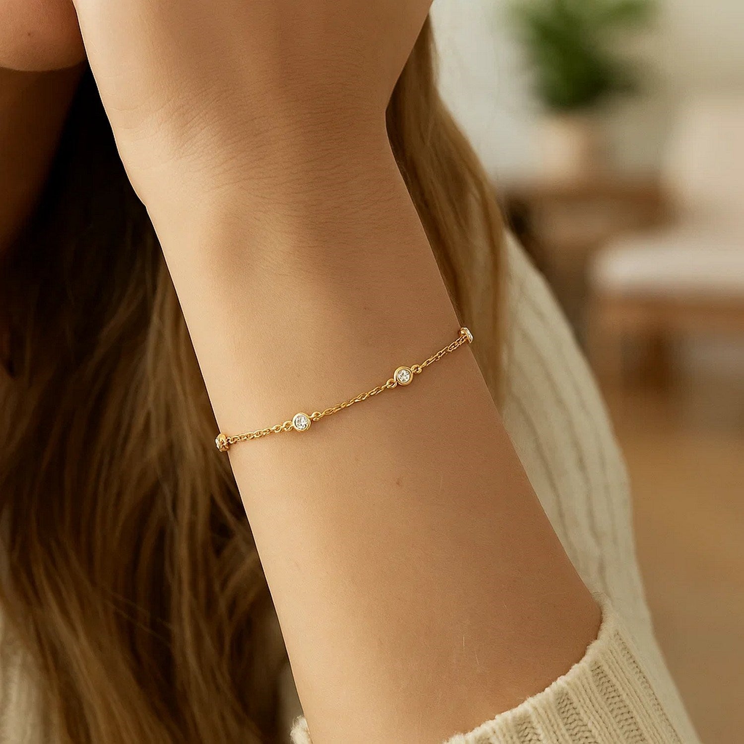 14k yellow gold bracelet with six round diamond stations on a woman's arm.