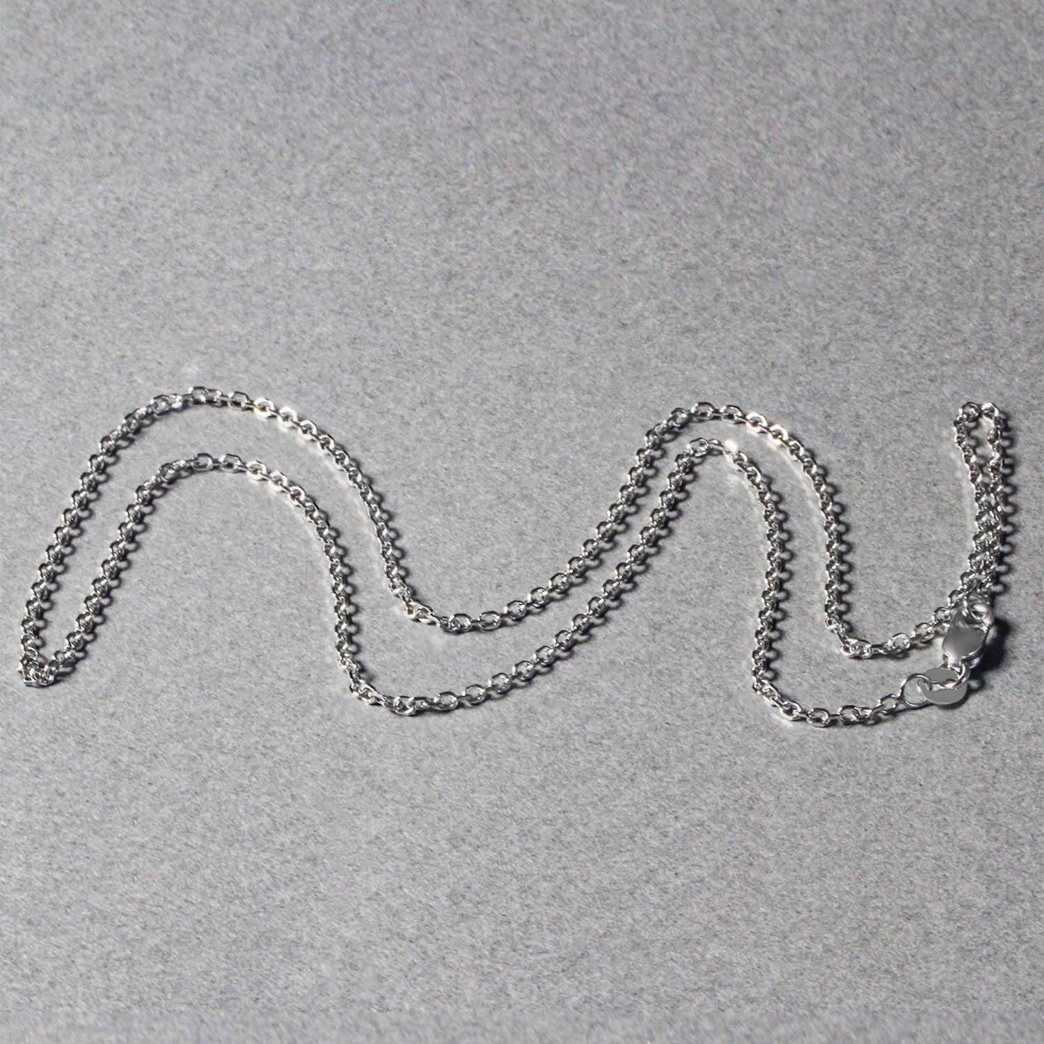 An 18k white gold diamond-cut cable link chain with a lobster clasp.