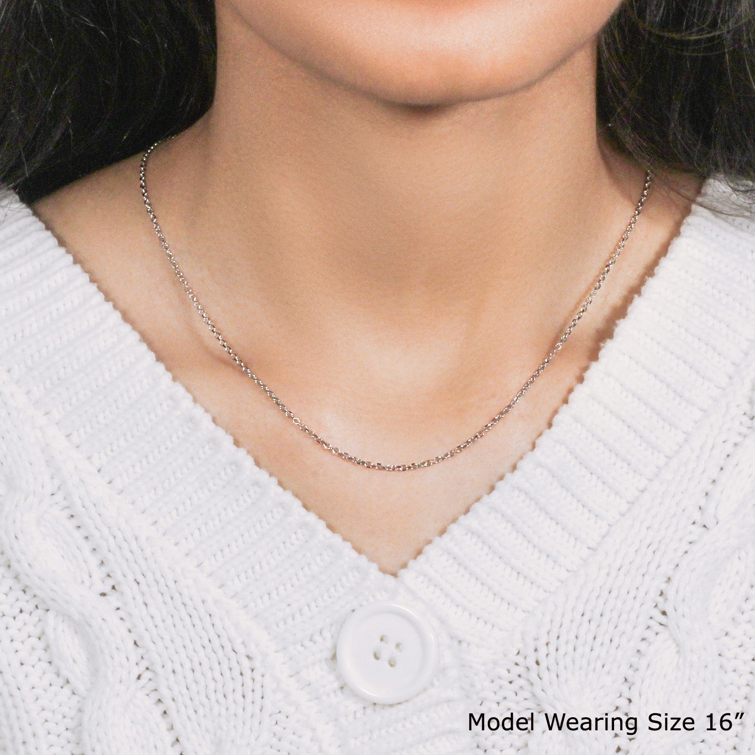 An 18k white gold diamond cut cable link chain is worn by a model.