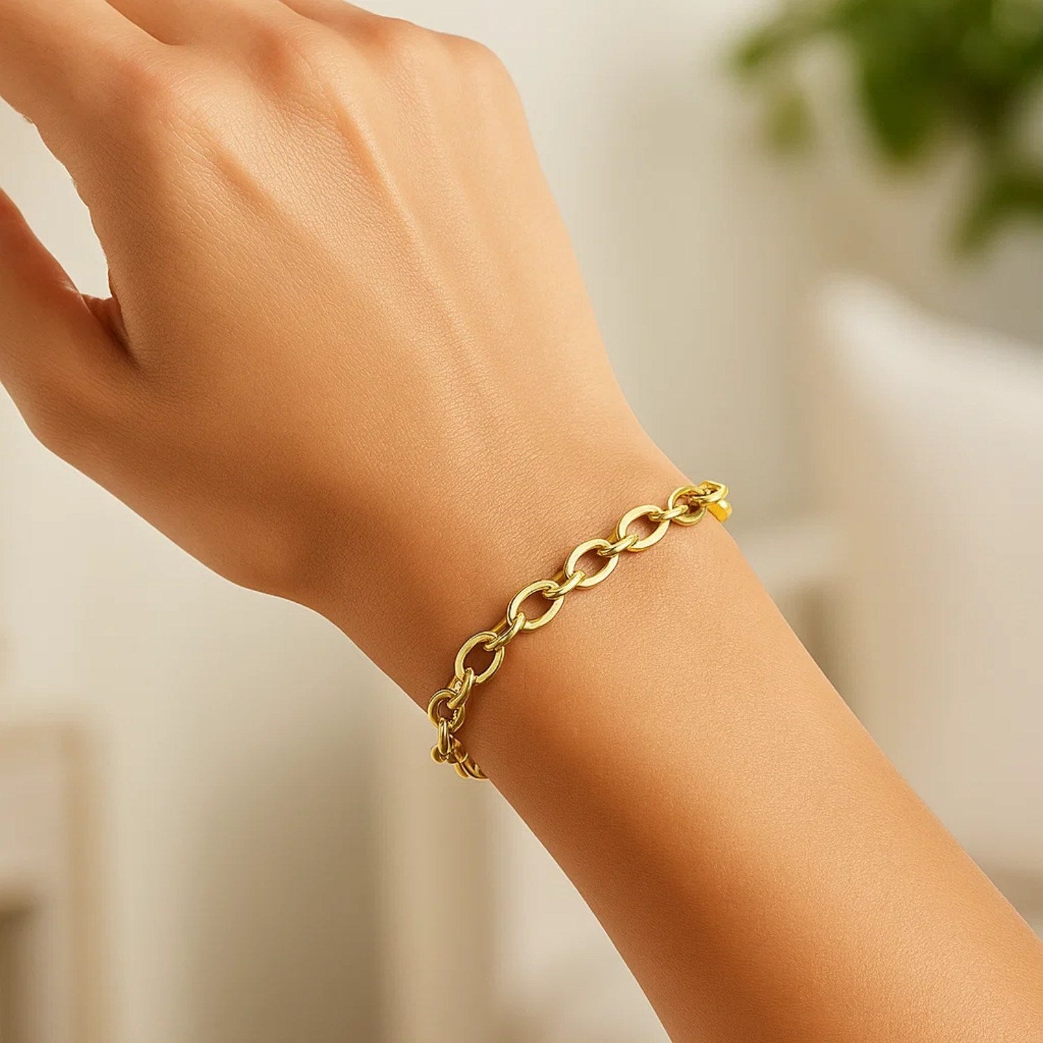 14k yellow gold cable chain style bracelet with polished oval links on a wrist.