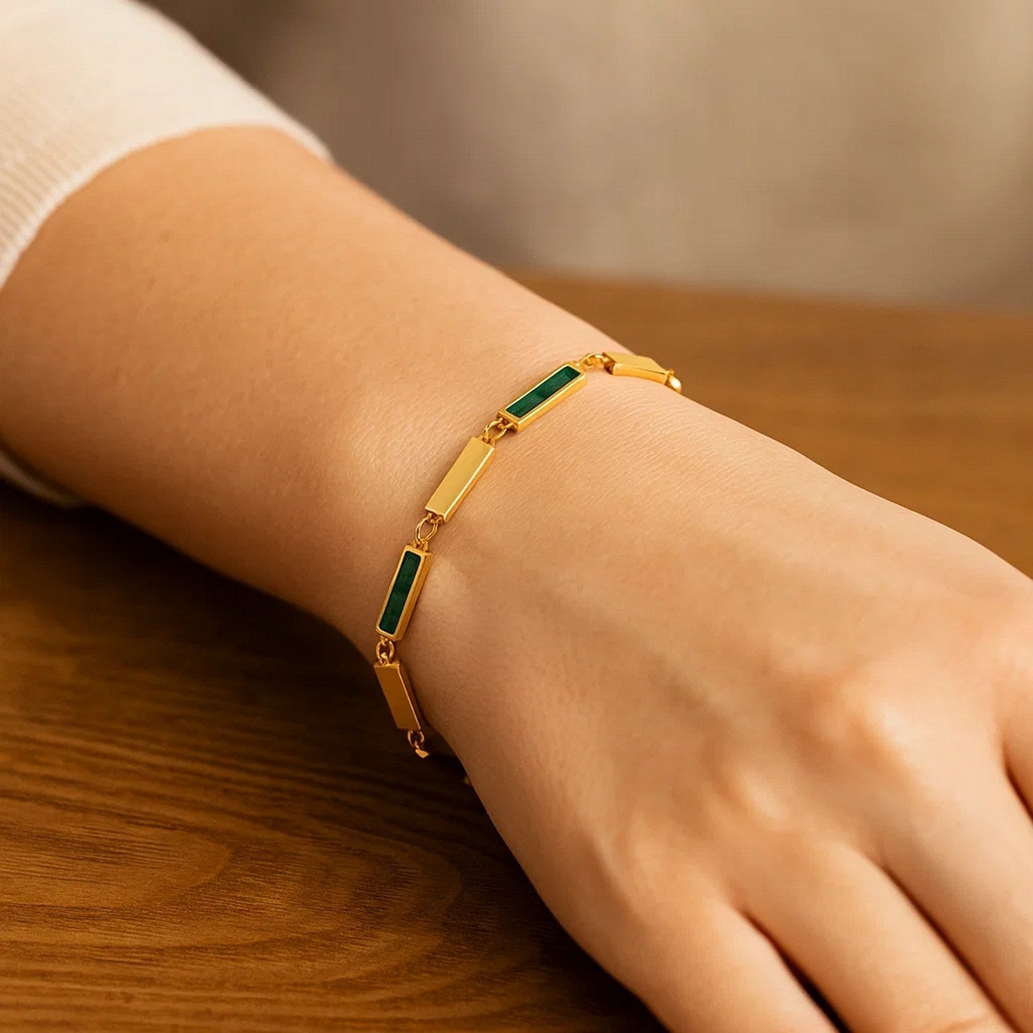 14K yellow gold bracelet with rectangular malachite links on a person's wrist.