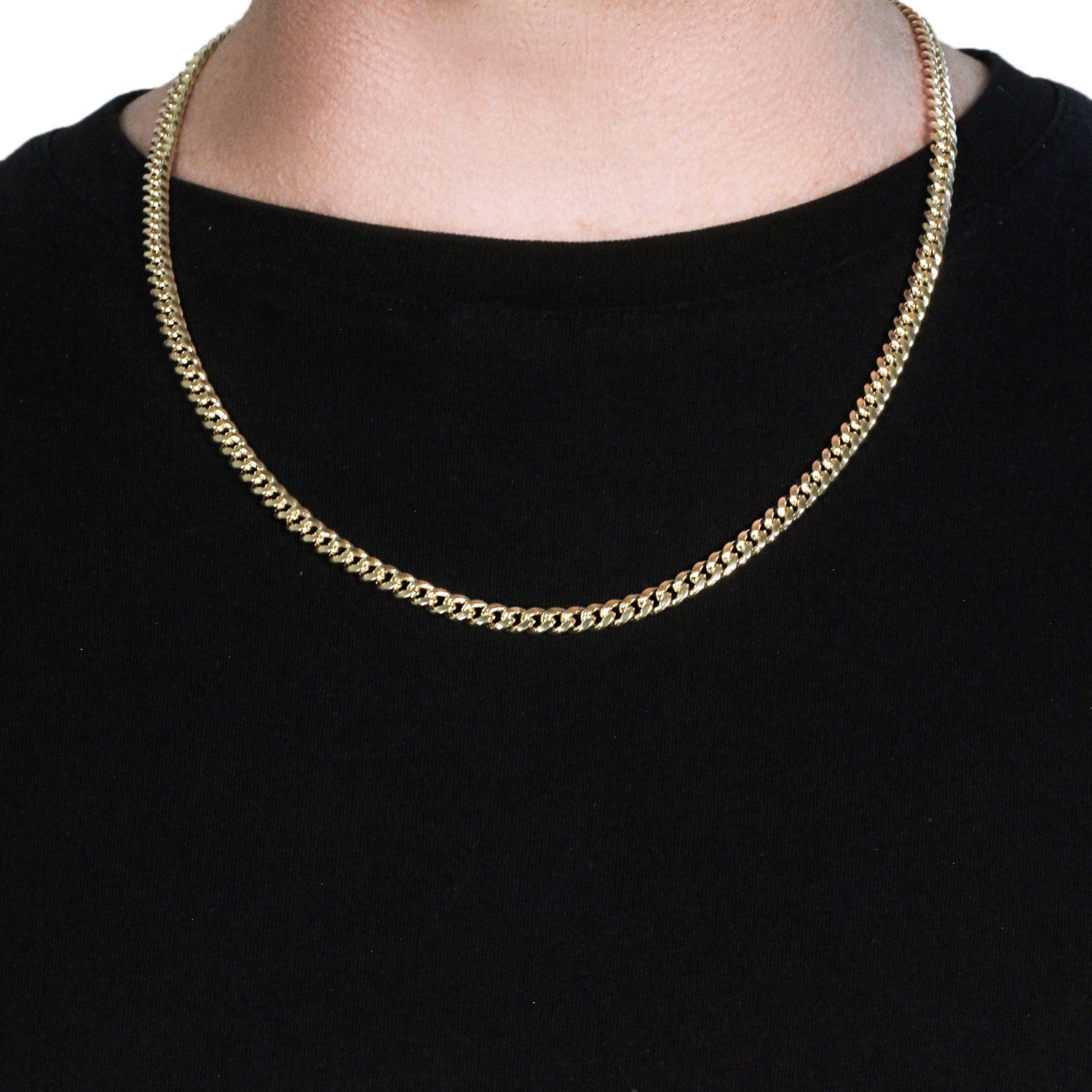 A 14k yellow gold semi-solid Miami Cuban chain is worn around a person's neck.
