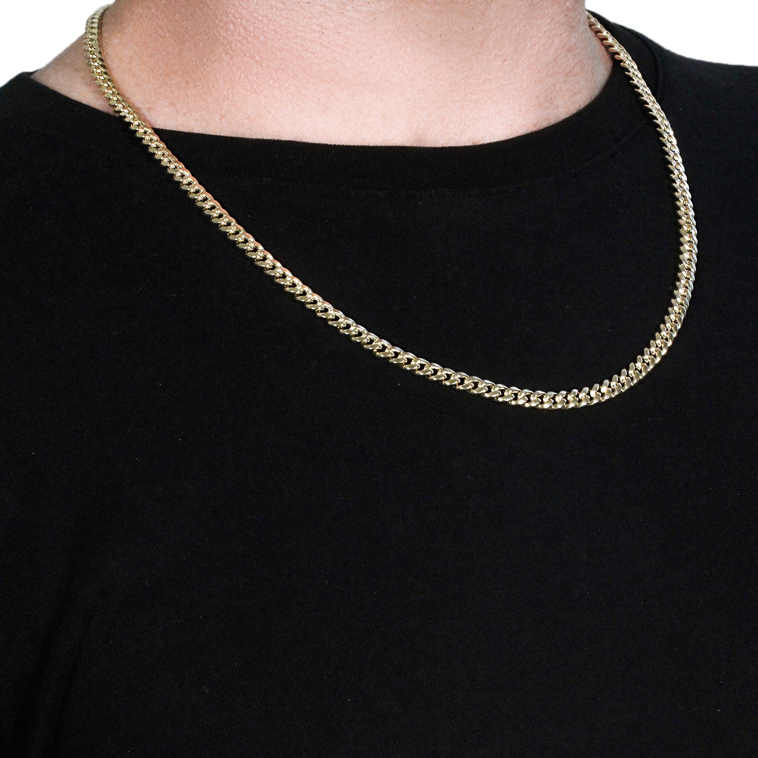 A 14k yellow gold semi-solid Miami Cuban chain, 5.00 mm wide, worn around a neck.