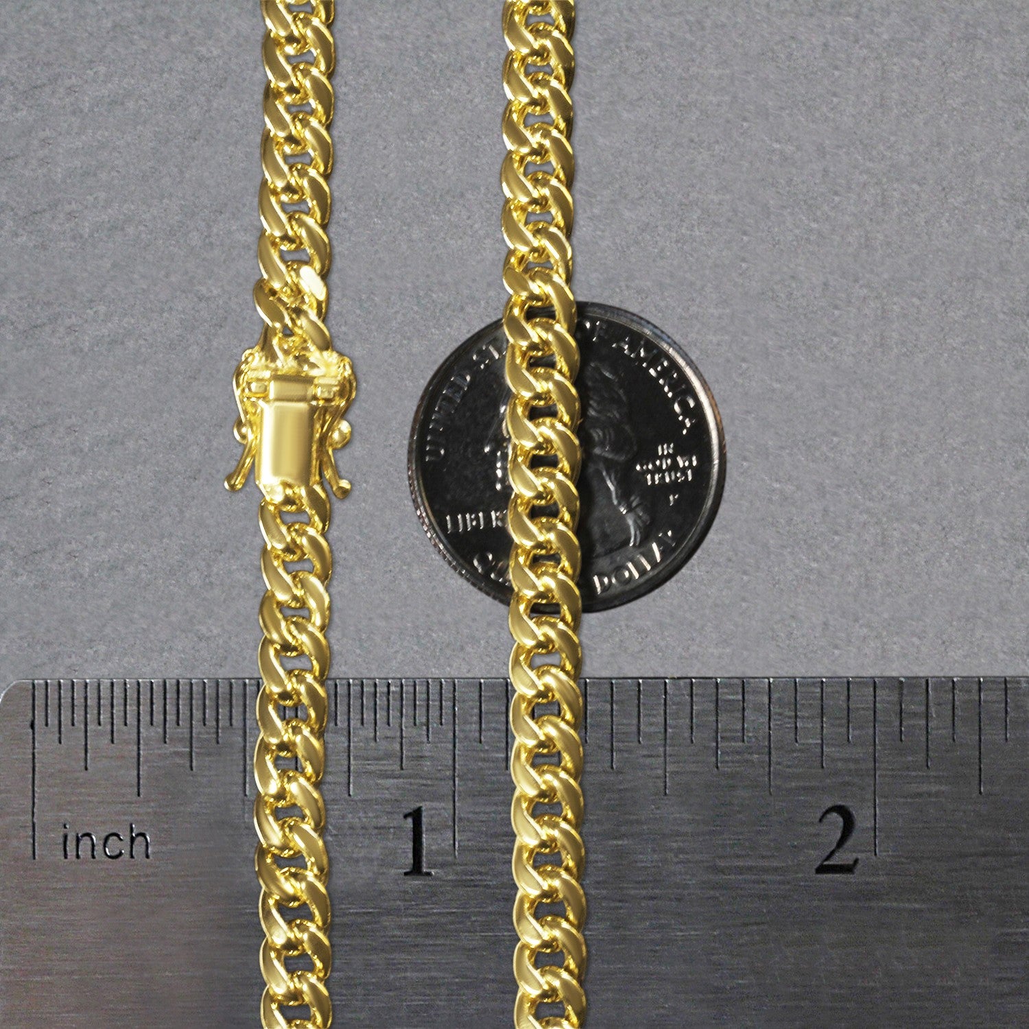 A 14k yellow gold semi-solid Miami Cuban chain with a box clasp, shown with a ruler and a quarter for scale.