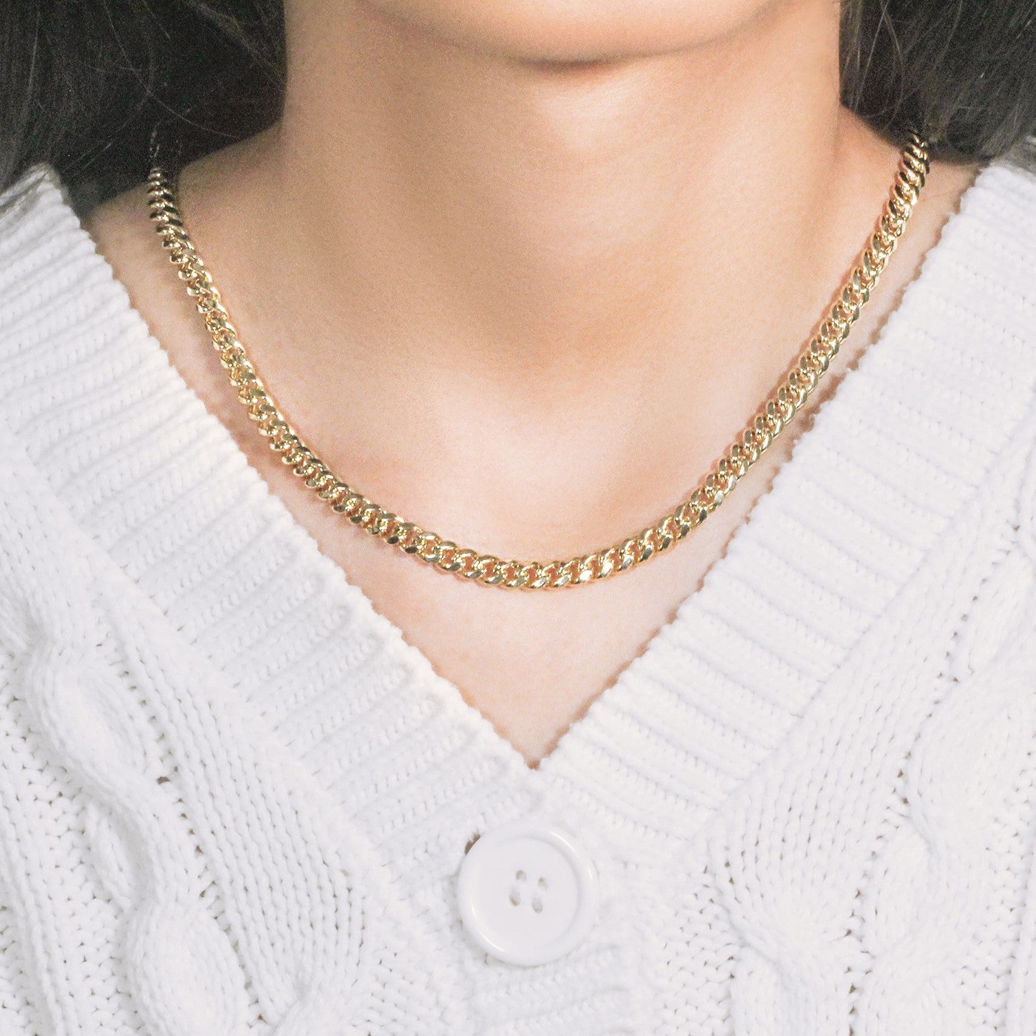 A 14k yellow gold semi-solid Miami Cuban chain, 5.00 mm wide, on a person.