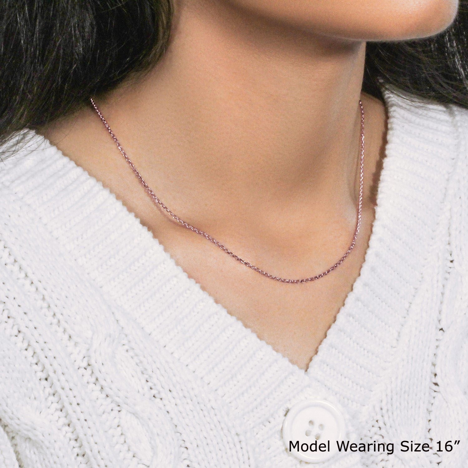 14k rose gold diamond cut cable link chain on a model wearing a white sweater.