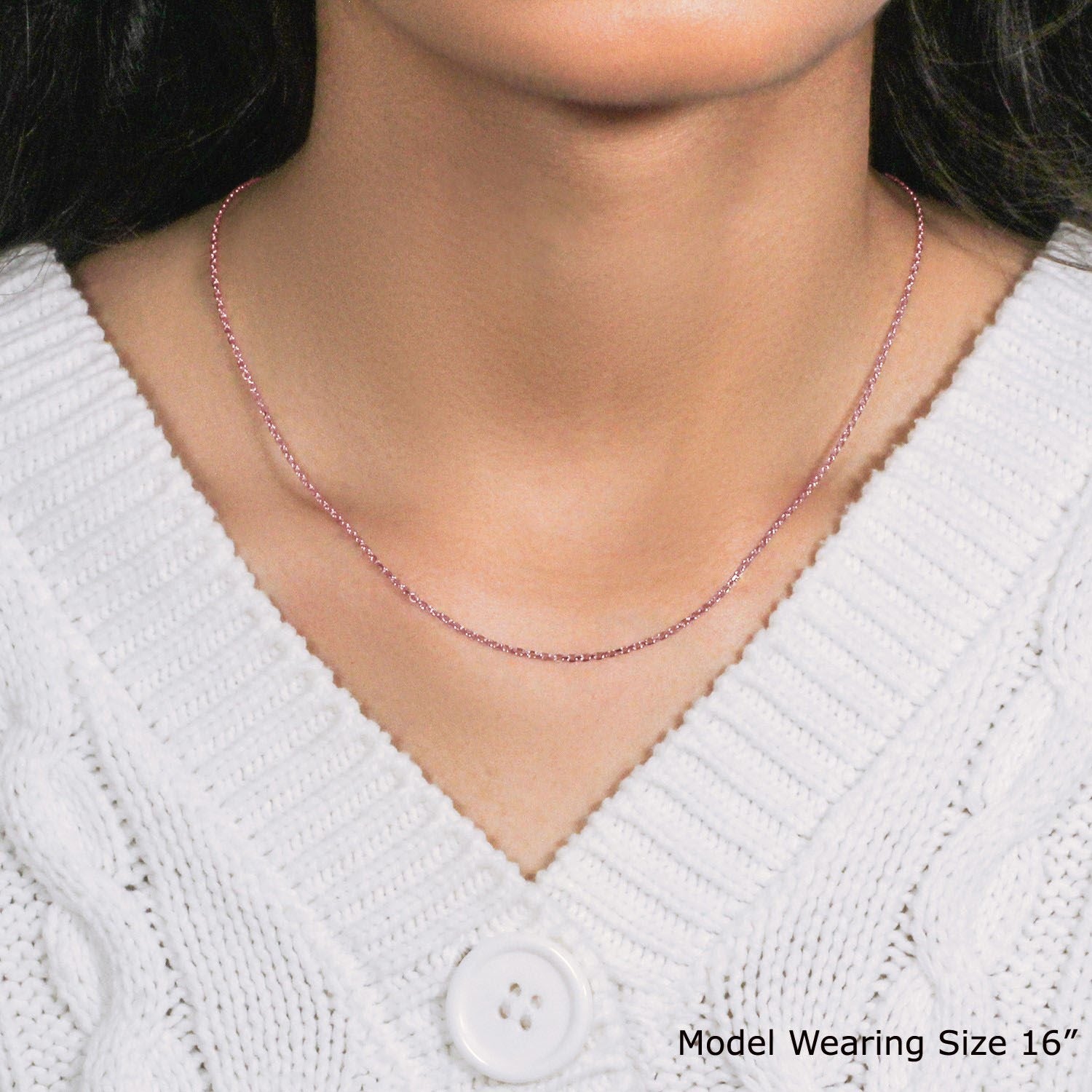 A 14k rose gold diamond cut cable link chain is worn around a person's neck.