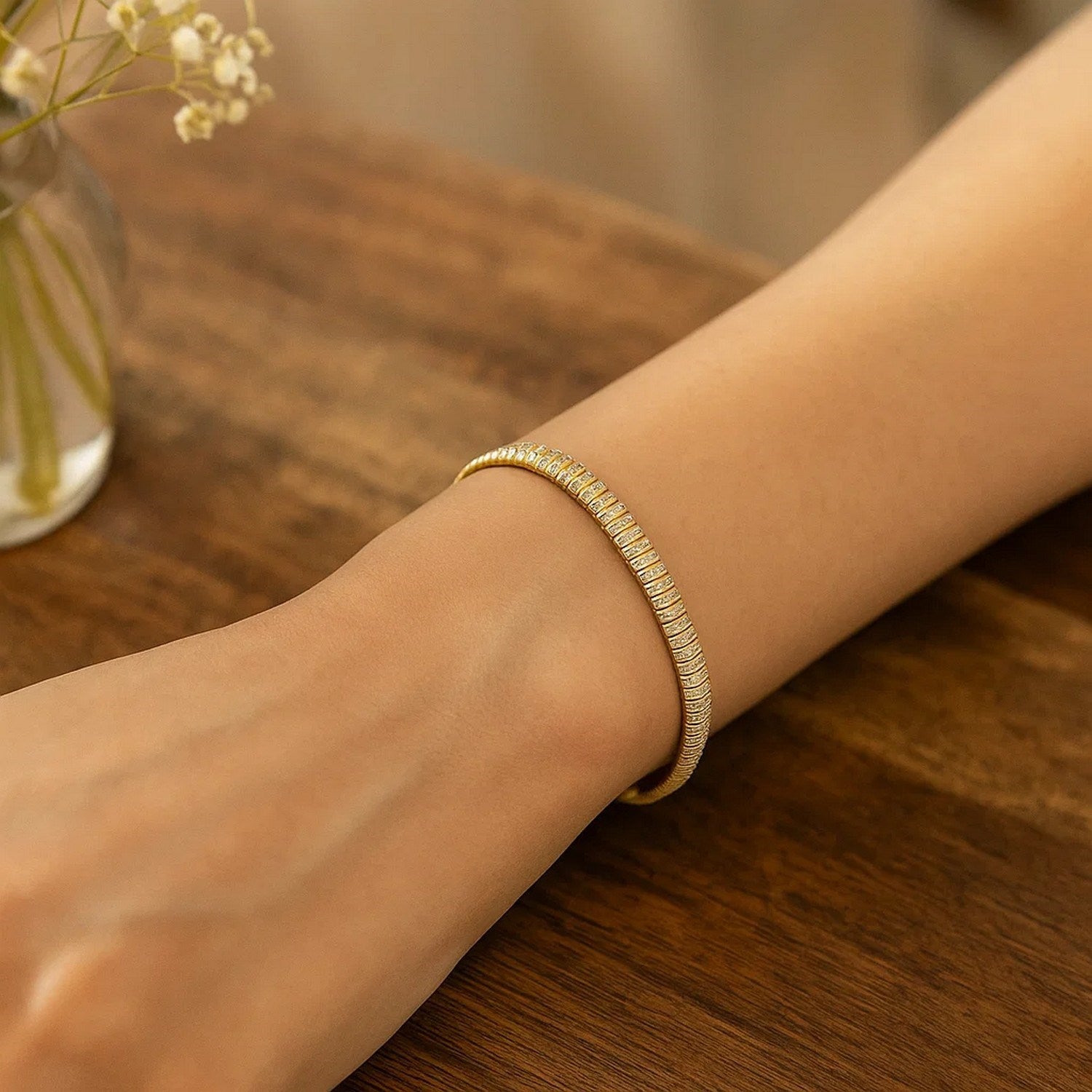 A 14k yellow gold diamante flex bracelet is worn on a person's wrist.