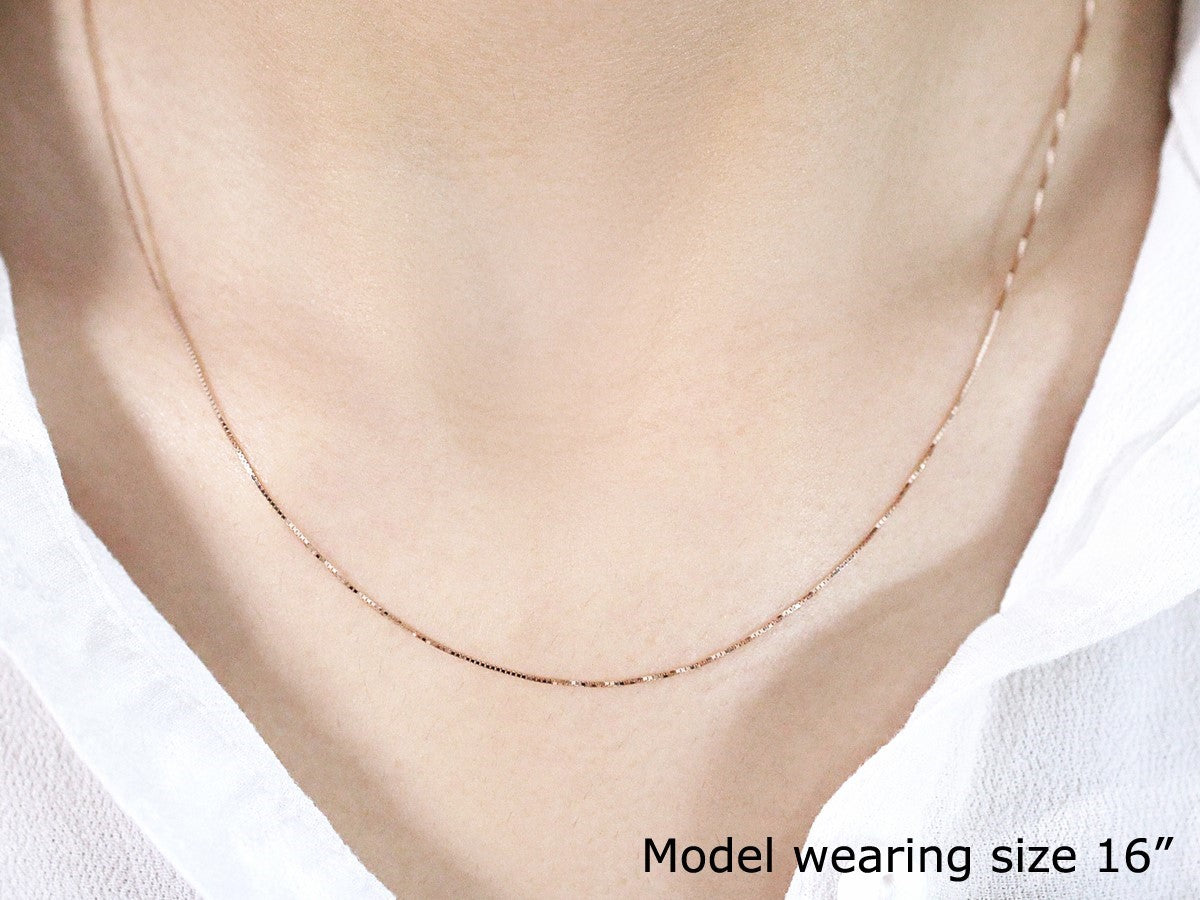 An 18k rose gold classic box chain, 0.60 mm wide, worn by a model.