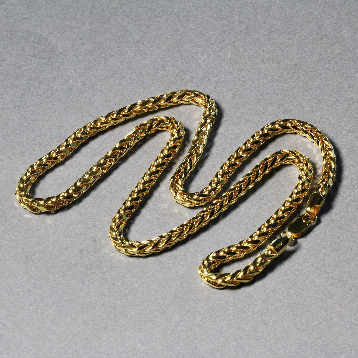 A 4.1mm 14k yellow gold diamond cut round Franco chain on a gray background.