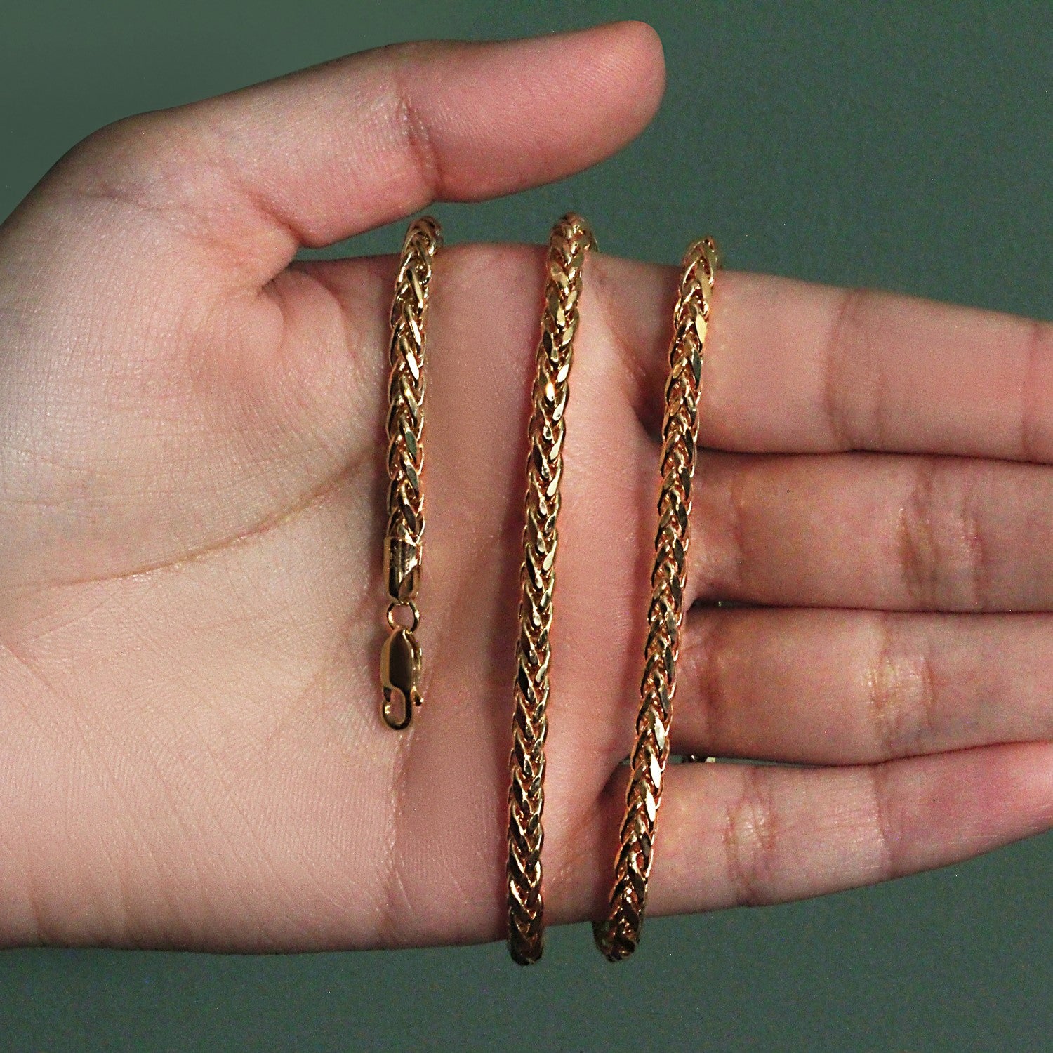 A 4.1mm 14k yellow gold diamond cut round Franco chain held in a hand.