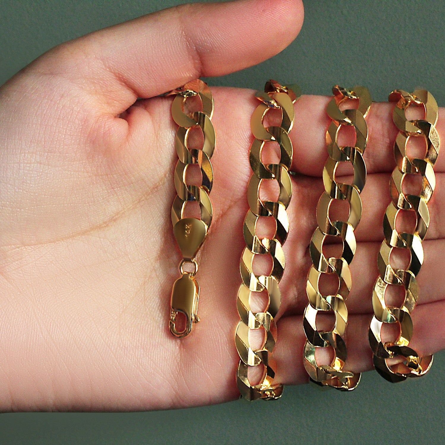 Solid 14k yellow gold curb chain, 11.23 mm wide, held in a hand.