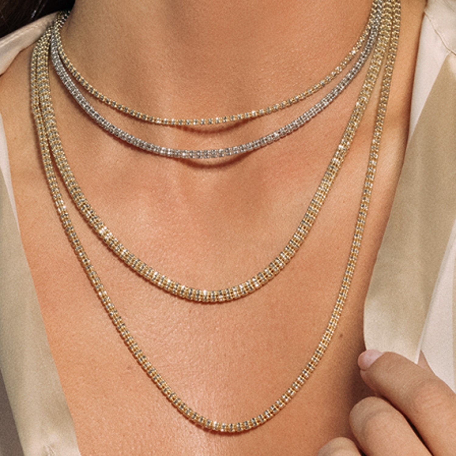 A woman wears five layered gold and silver barrel chains.