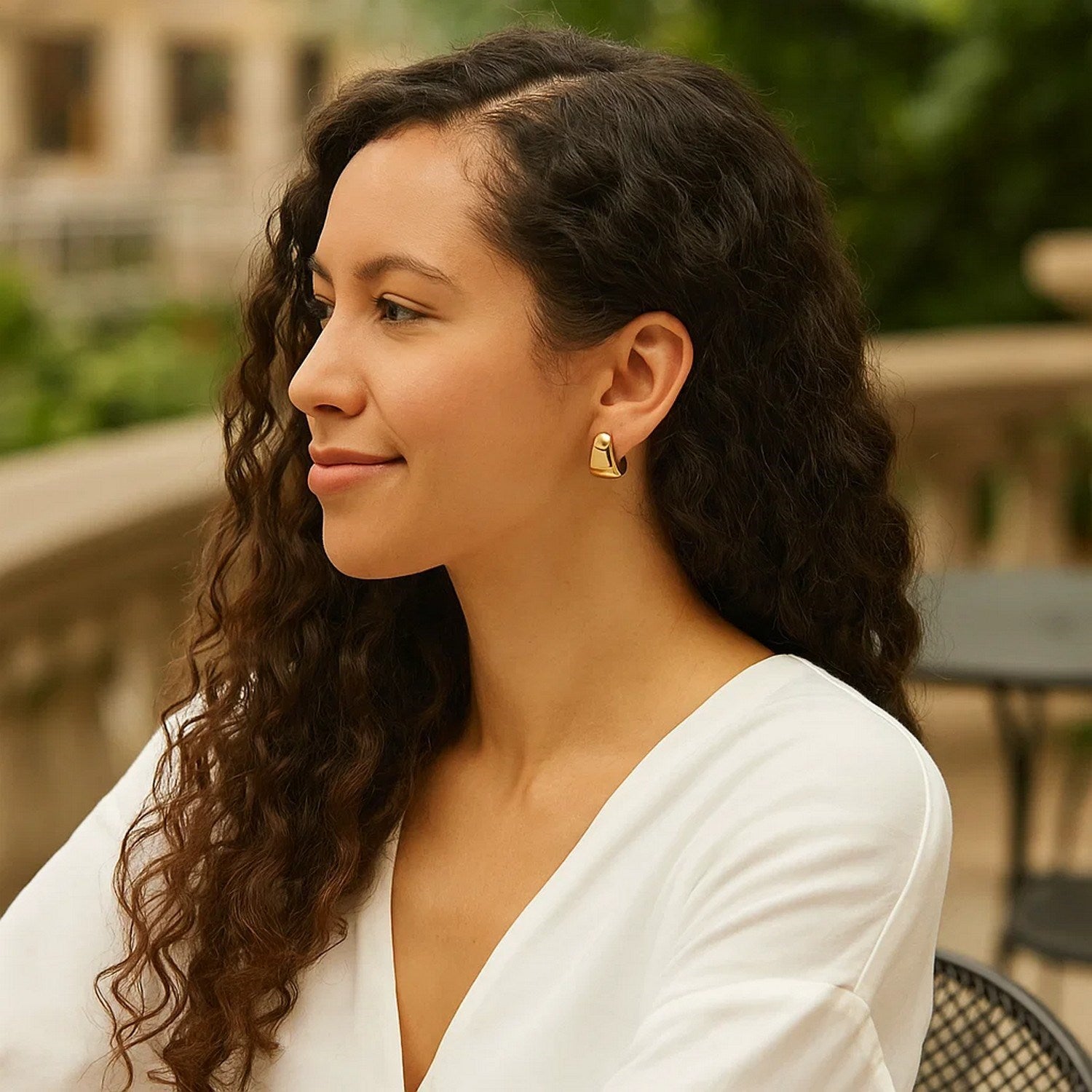 Puffed Up Graduated Hoop Earrings in 14K Yellow Gold on a woman's ear.