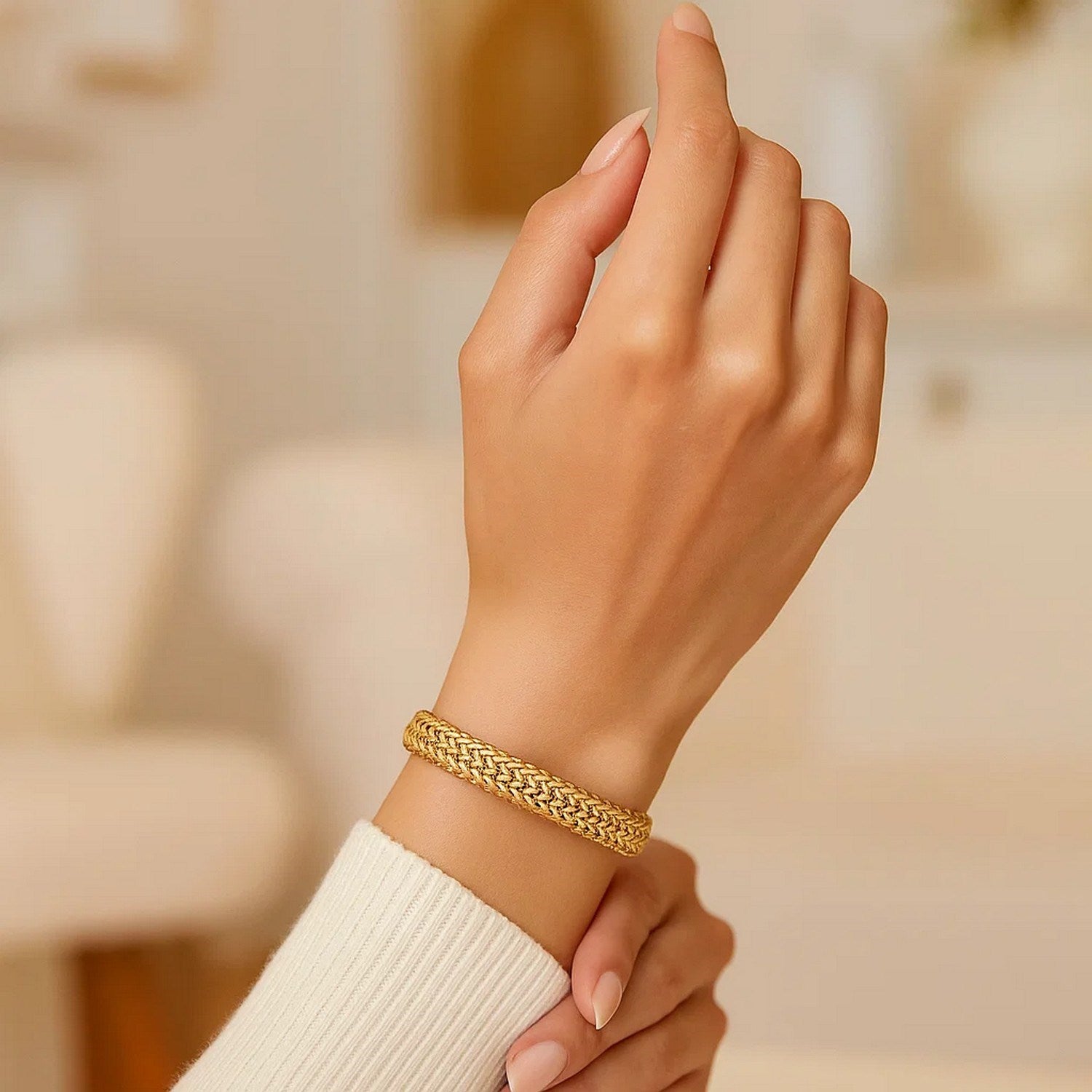 14k yellow gold high polish thick braided bracelet on a woman's wrist.