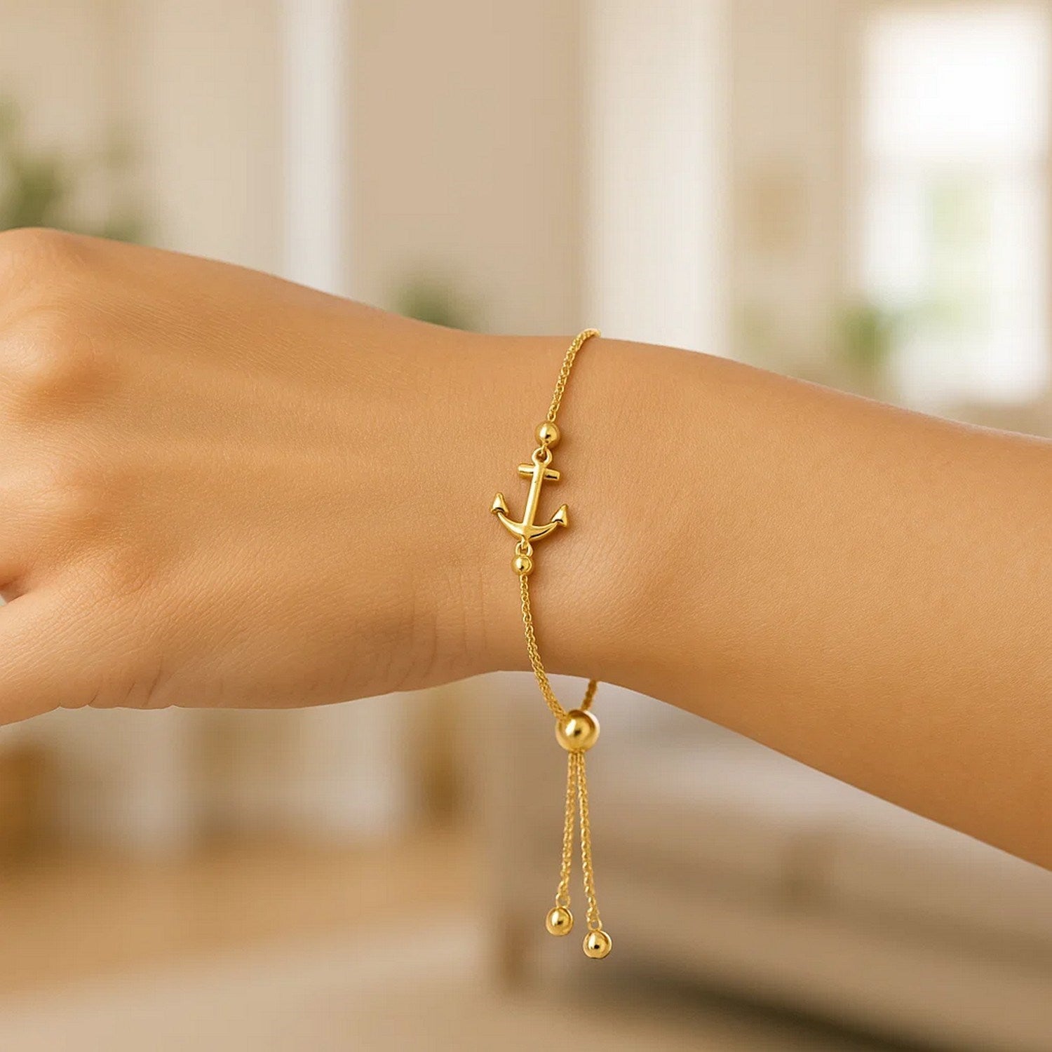 14k yellow gold adjustable lariat bracelet with an anchor design.