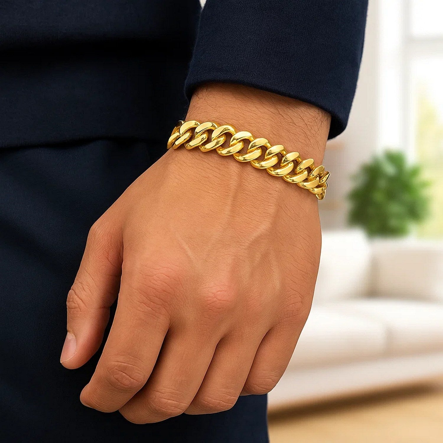 A polished 14k yellow gold curb chain bracelet is worn on a person's wrist.
