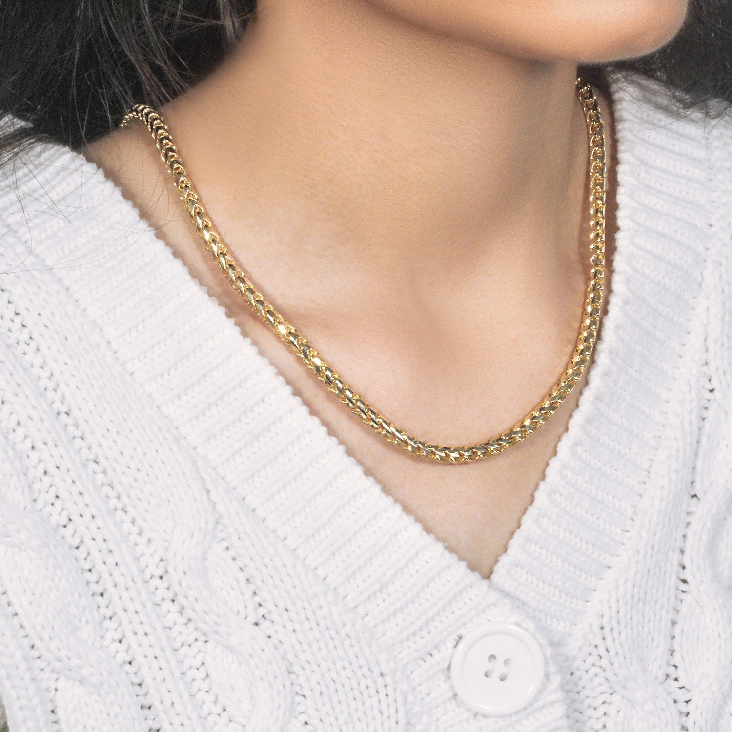14k yellow gold diamond cut round Franco chain on a person wearing a white sweater.