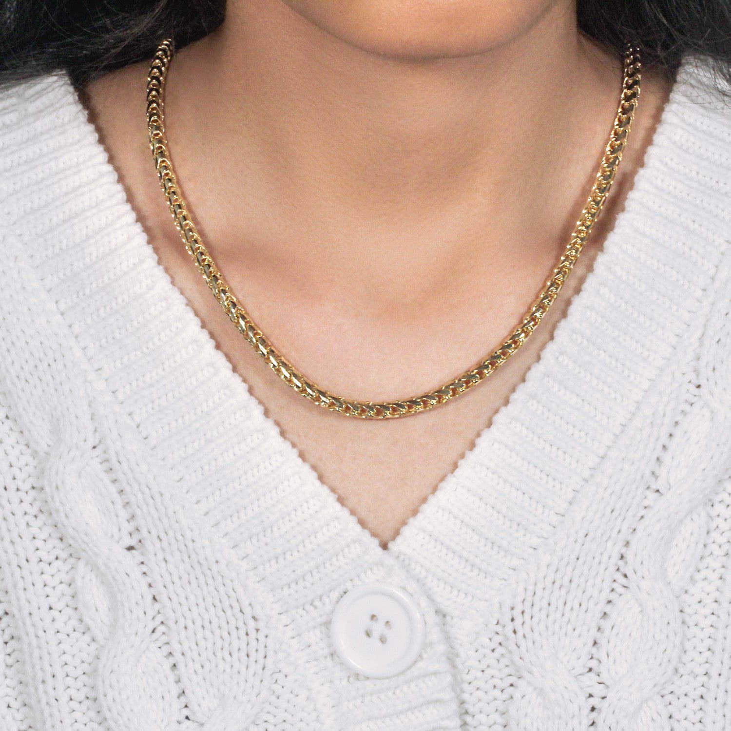 14k yellow gold diamond cut round Franco chain on a person wearing a white sweater.