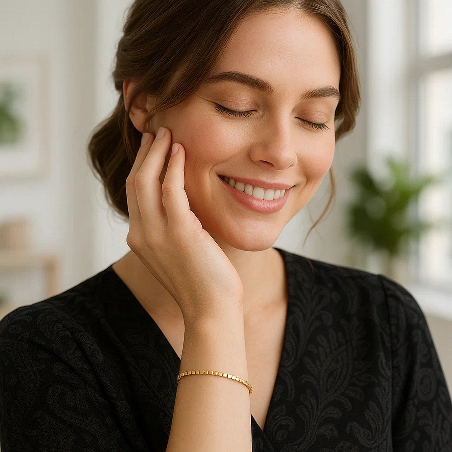 A woman smiles, wearing a 14K yellow gold mini cube bracelet.