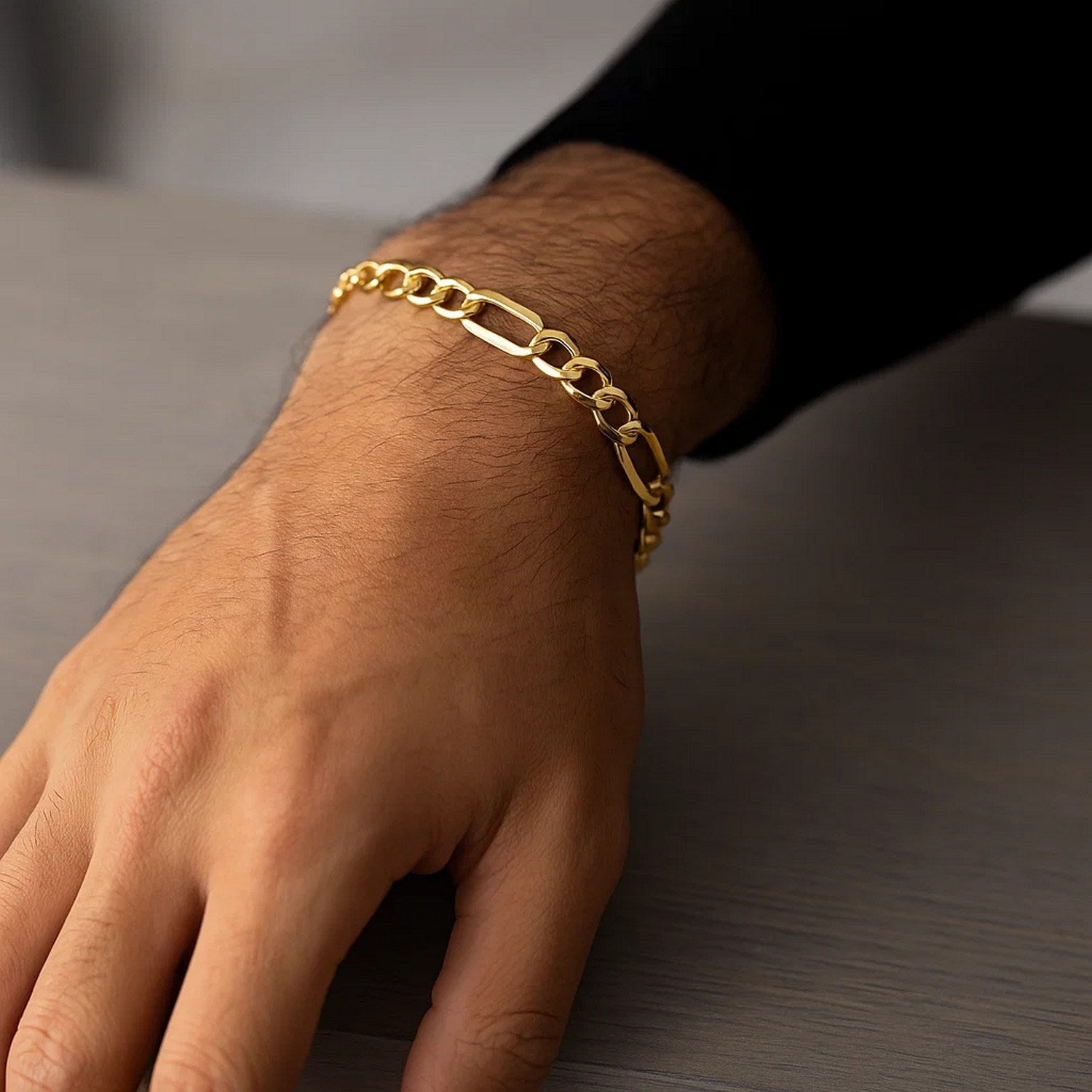 10k yellow gold lite Figaro bracelet on a person's wrist.
