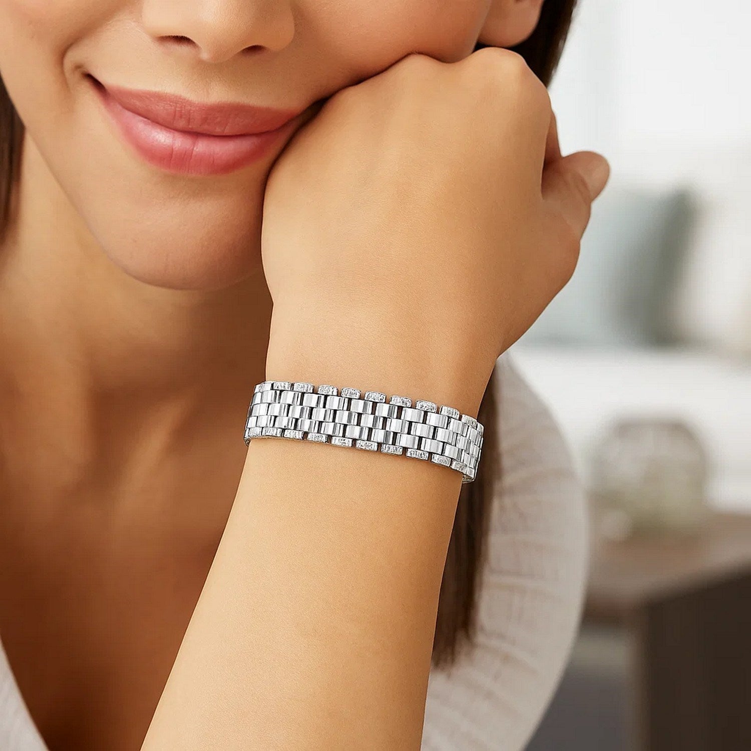 A woman wears a 14k white gold faceted panther link chain bracelet on her left wrist.