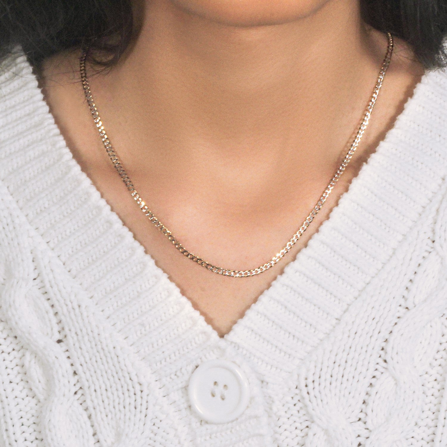 A 14k two-tone gold pave curb chain, 2.60 mm wide, is worn around a person's neck.