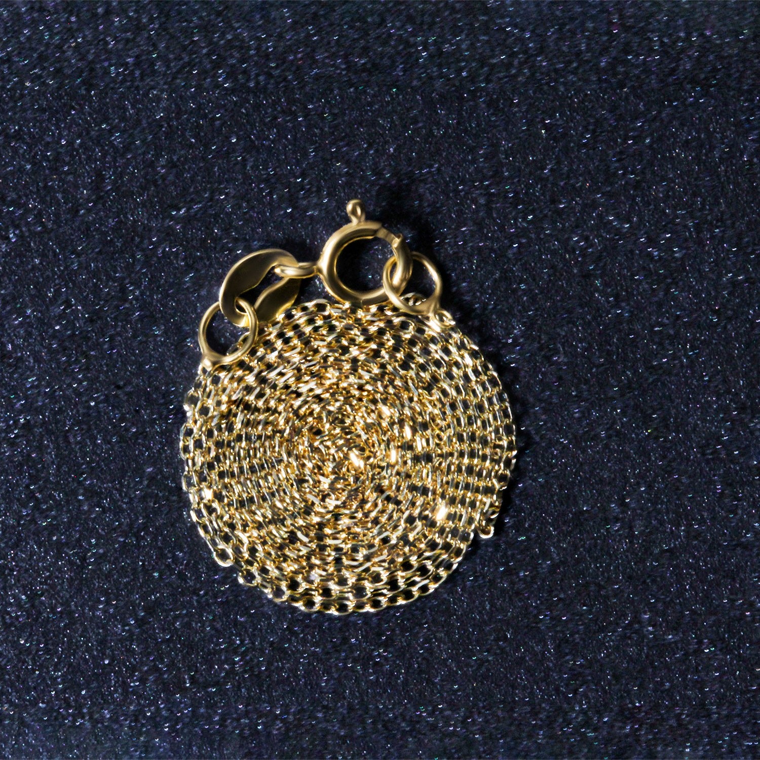 10k yellow gold diamond cut cable link chain with a lobster clasp, coiled on a dark surface.