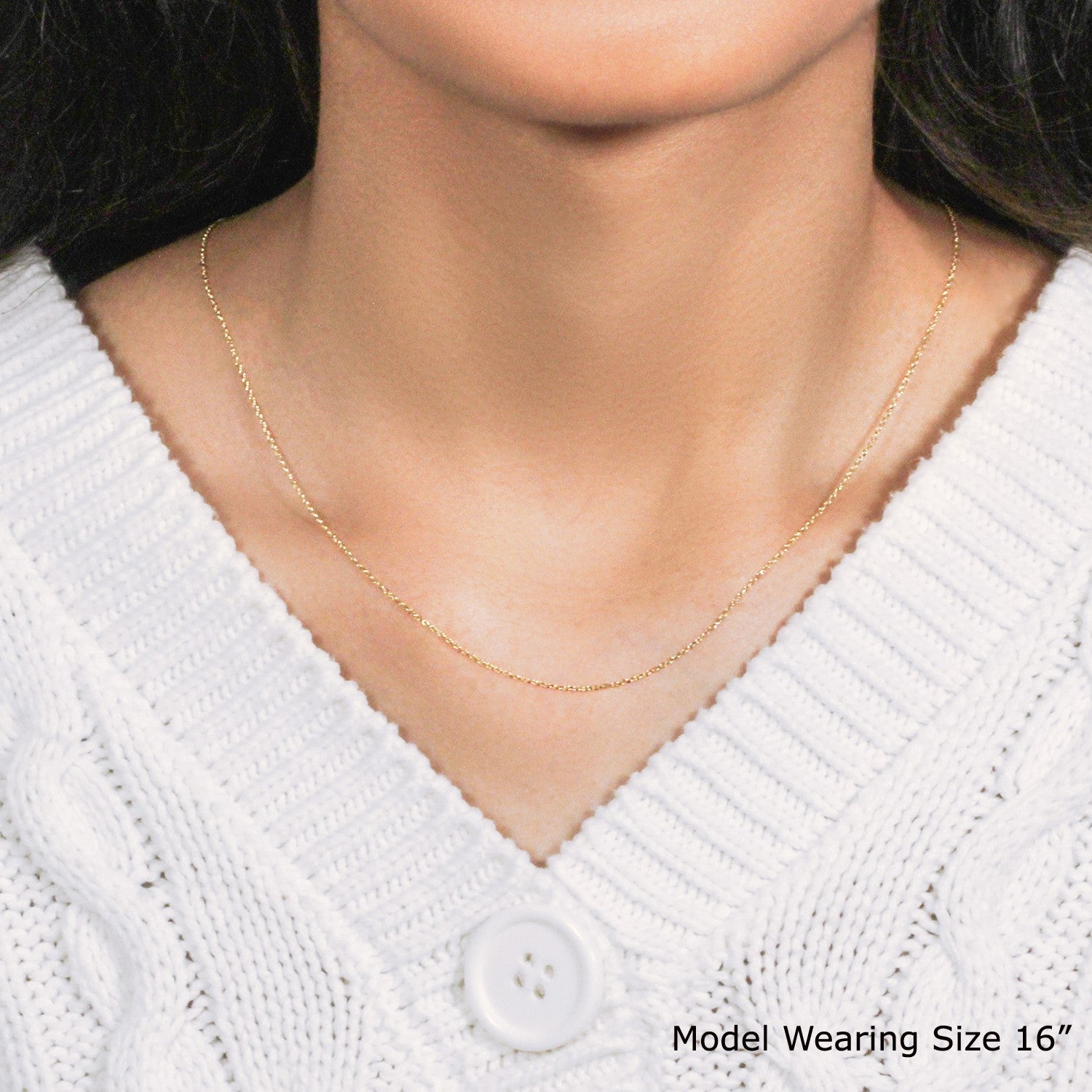A 10k yellow gold diamond cut cable link chain worn by a model.