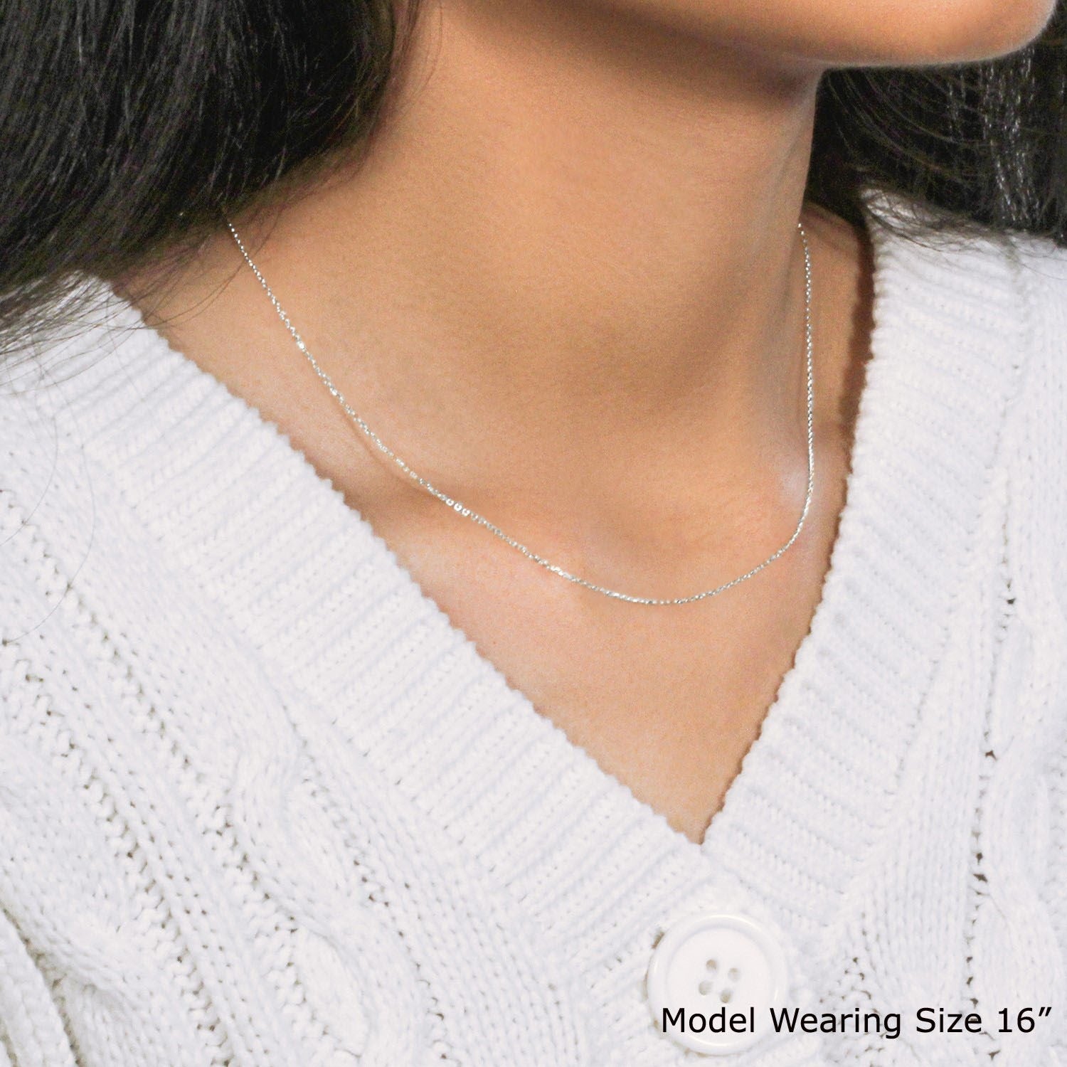 An 18k white gold diamond cut cable link chain worn by a model.