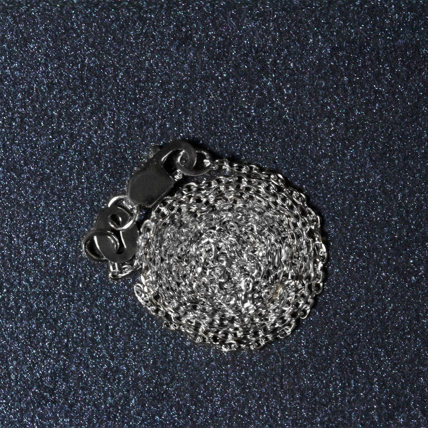 18k white gold diamond cut cable link chain with a lobster clasp, coiled on a dark background.
