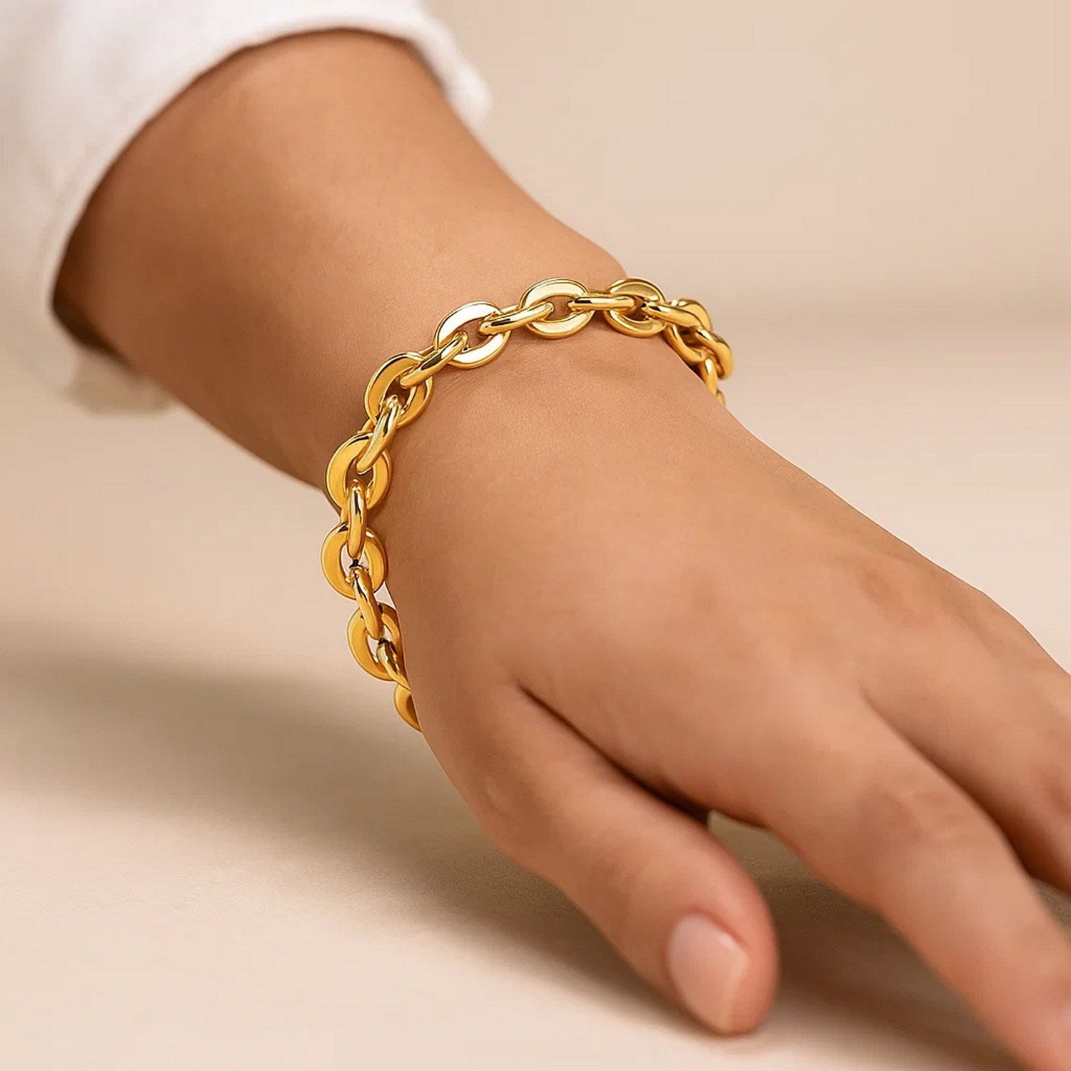 A 14K yellow gold mirror rolo link chain bracelet is worn on a wrist.