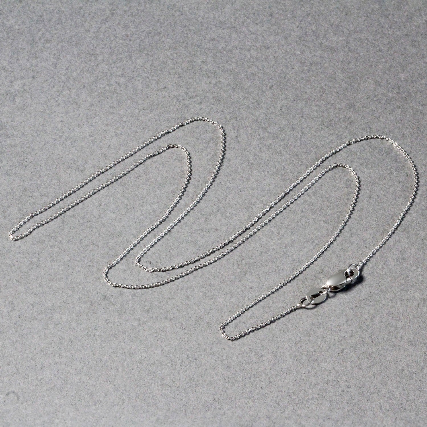 A delicate 14k white gold cable link chain with a lobster clasp.
