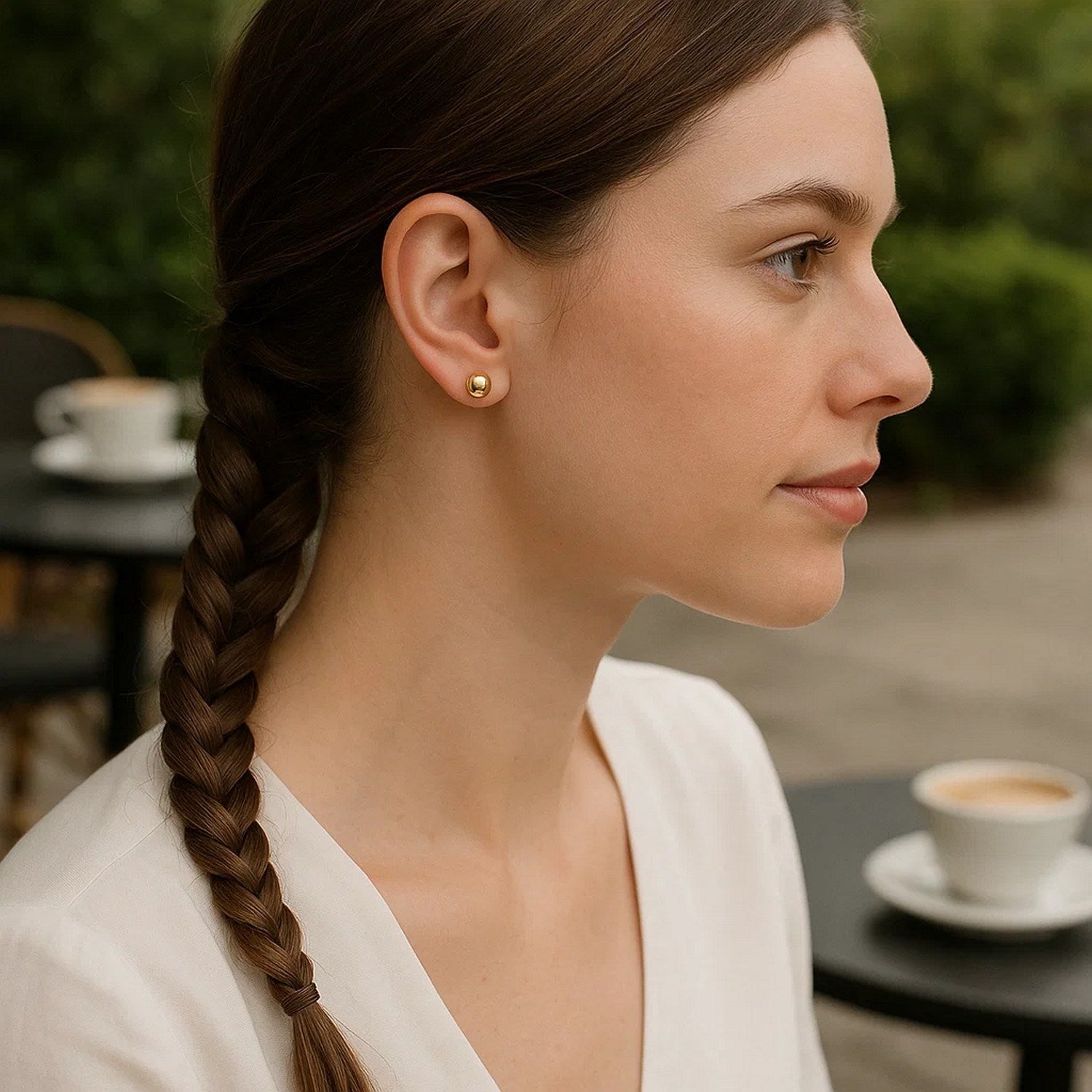 10k yellow gold round stud earrings on a woman's ear.