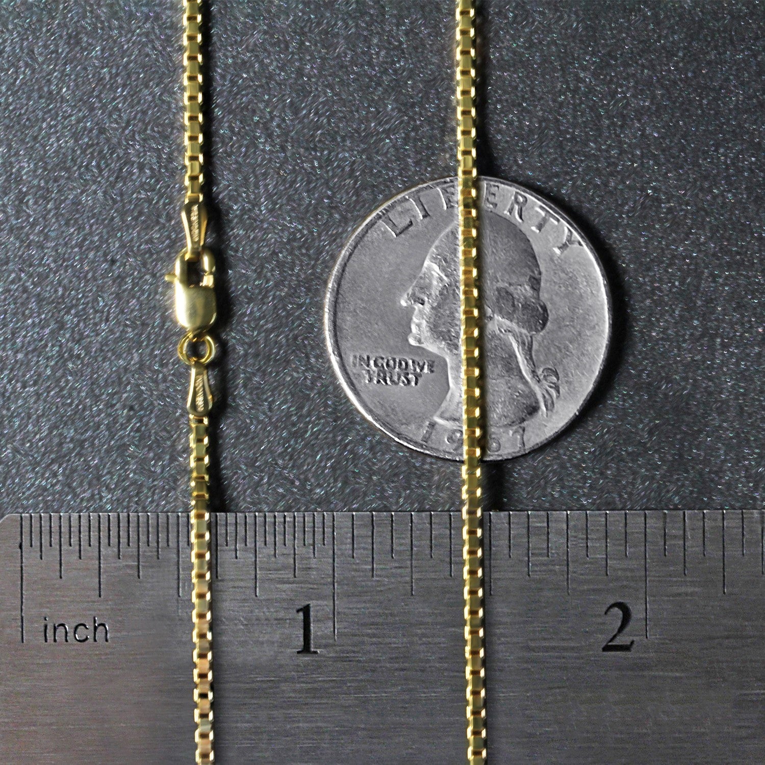 A 10k yellow gold box chain with a lobster clasp is shown next to a ruler and quarter.