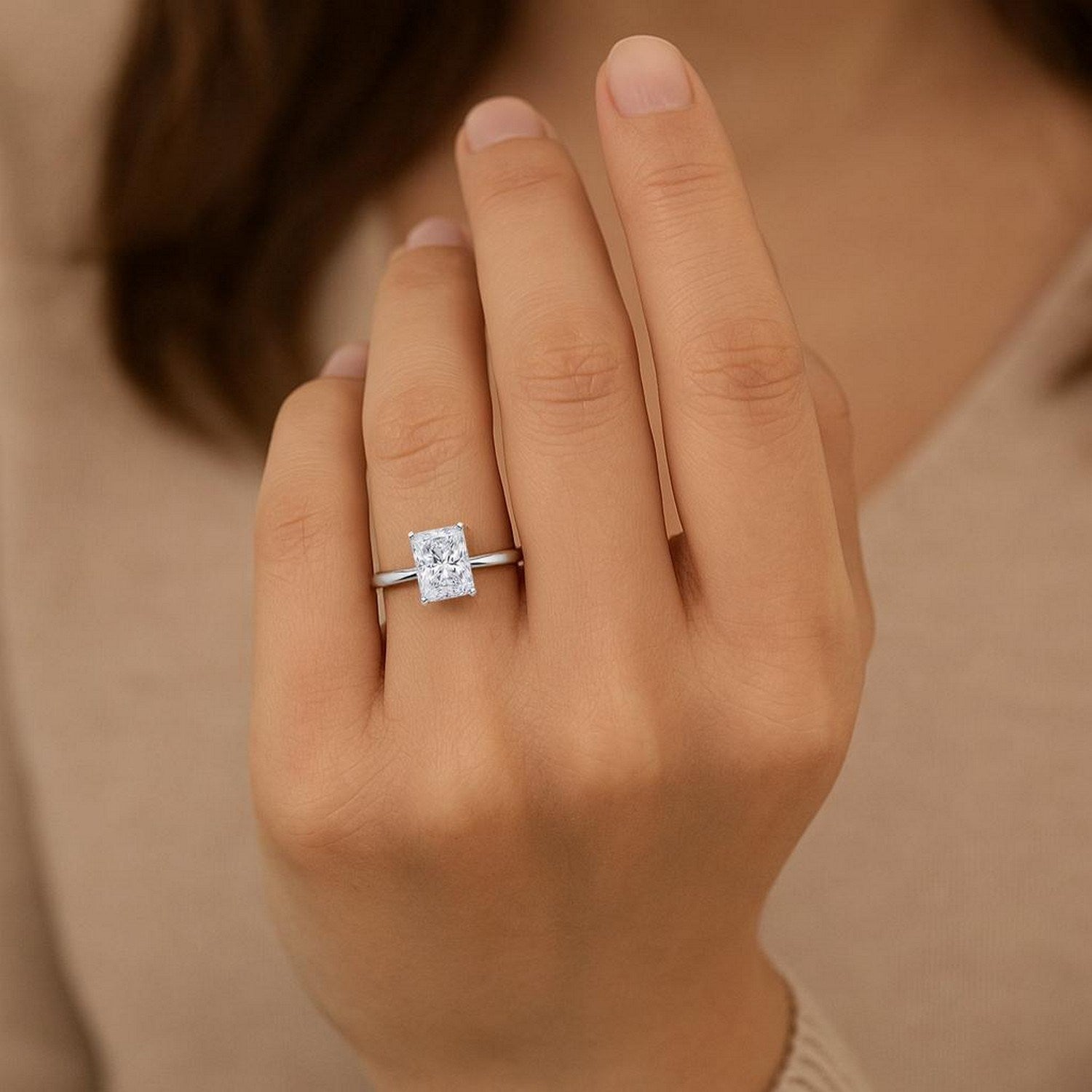 A radiant lab-grown diamond solitaire ring in 10K white gold on a hand.