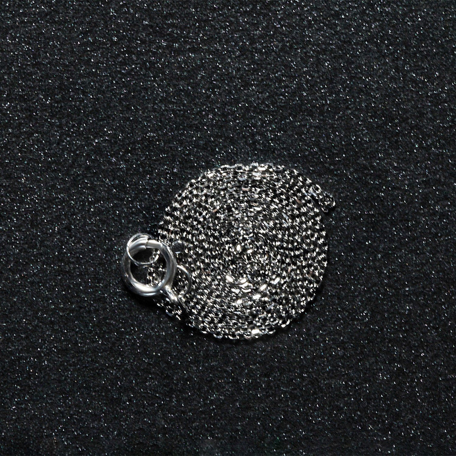A coiled 14k white gold diamond cut cable link chain with a spring ring clasp.