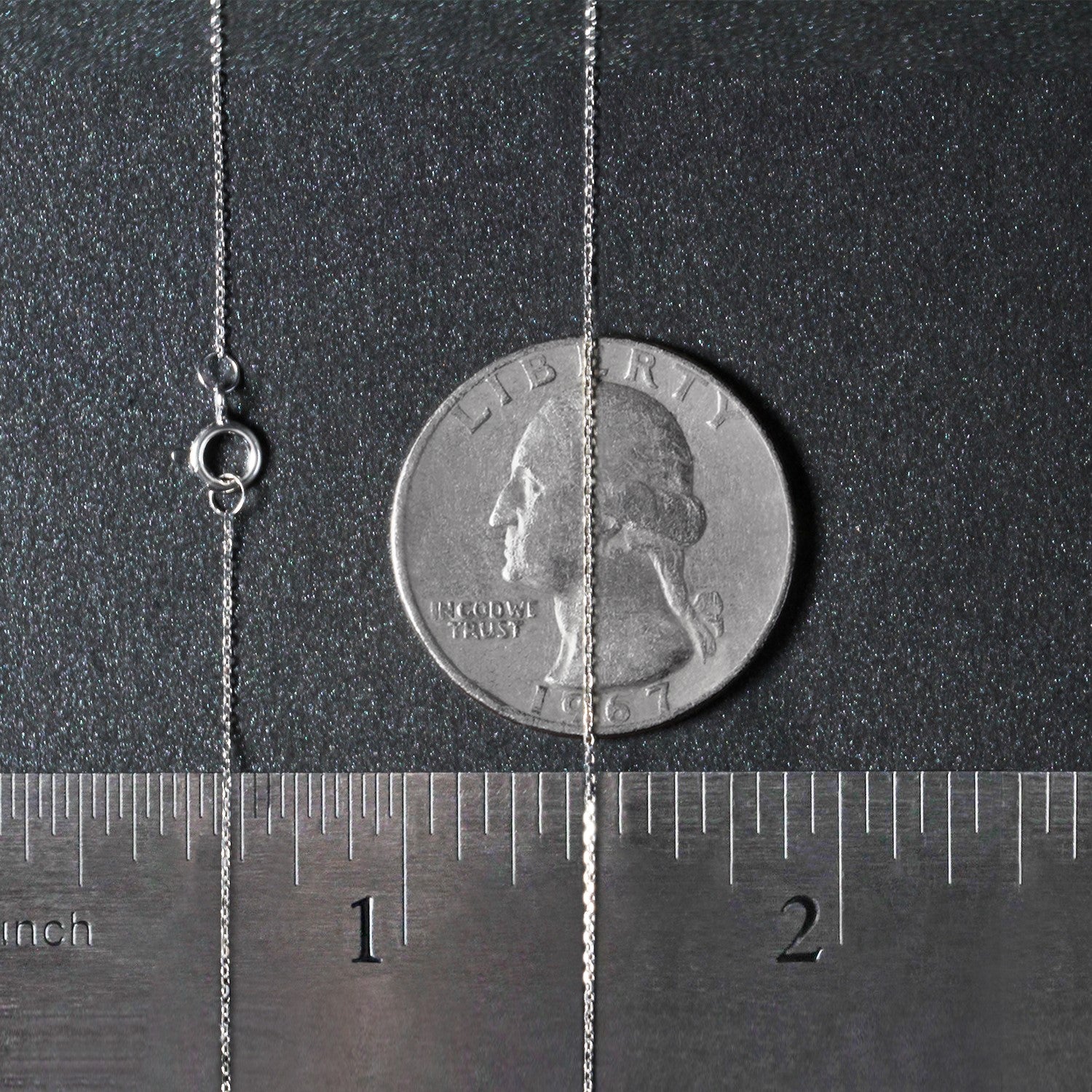 A 14k white gold diamond cut cable link chain with a spring ring clasp, shown next to a quarter and ruler.