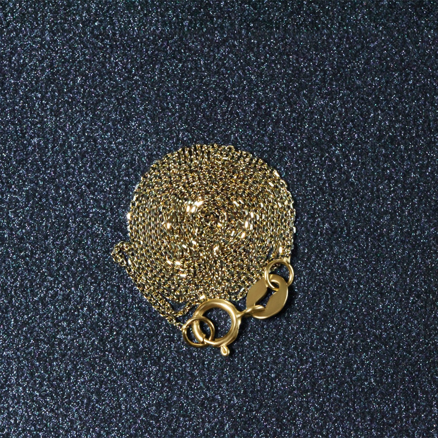 A coiled 14k yellow gold diamond cut cable link chain with a spring ring clasp.