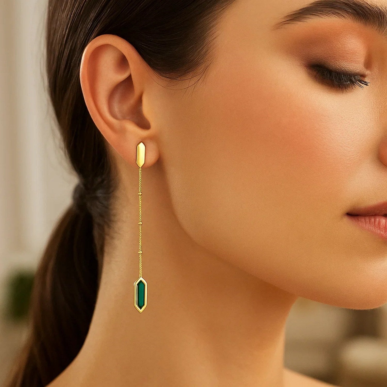 14K yellow gold hexagon malachite drop earring on a woman's ear.