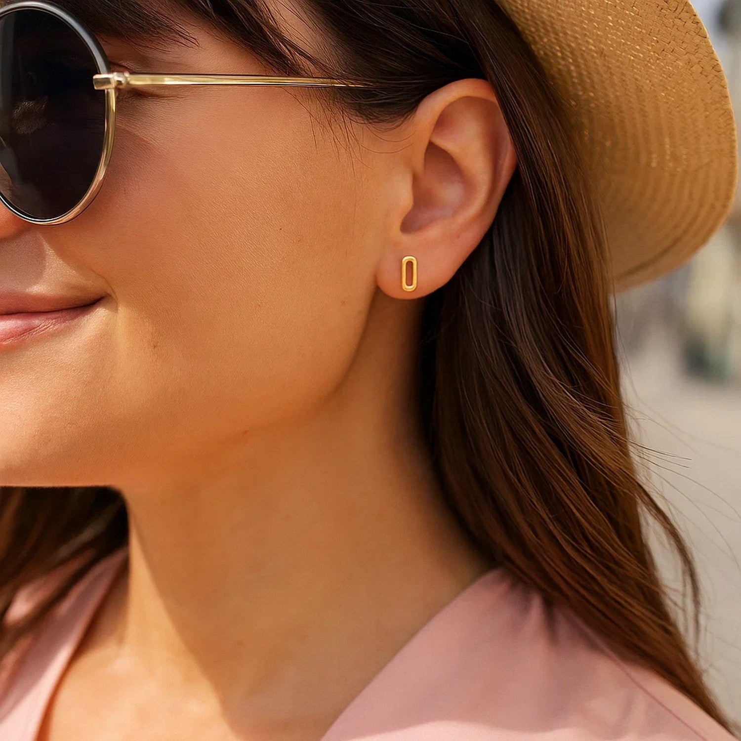 14k yellow gold paperclip link stud earrings on a woman's ear.