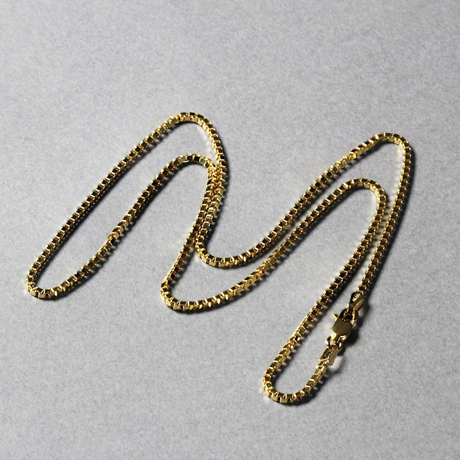 A 14K yellow gold classic box chain with a lobster clasp.