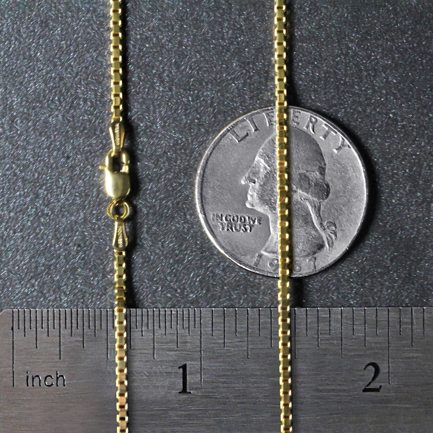 A 14K yellow gold classic box chain with a lobster clasp, measured against a ruler and coin.