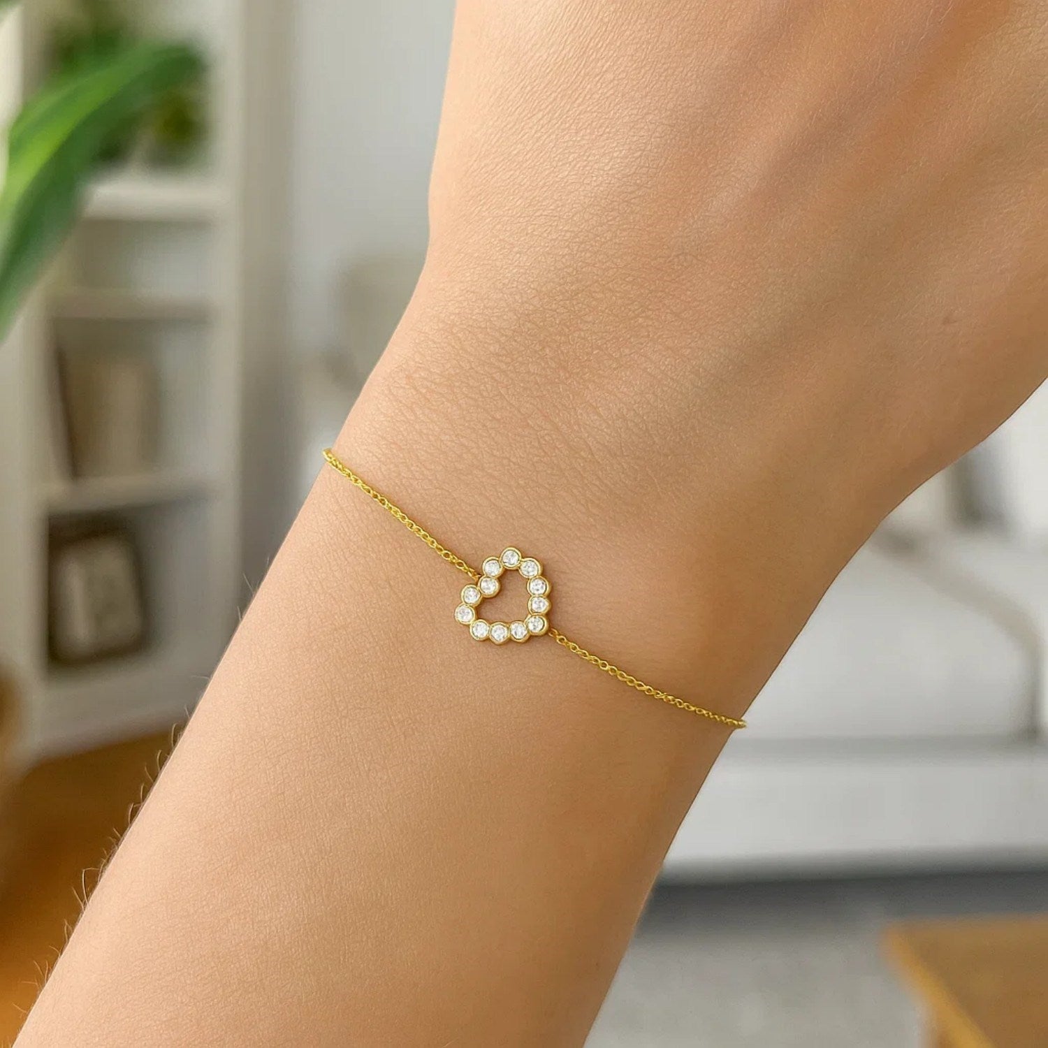 Elegant 14k yellow gold petite diamond heart bracelet on a wrist.