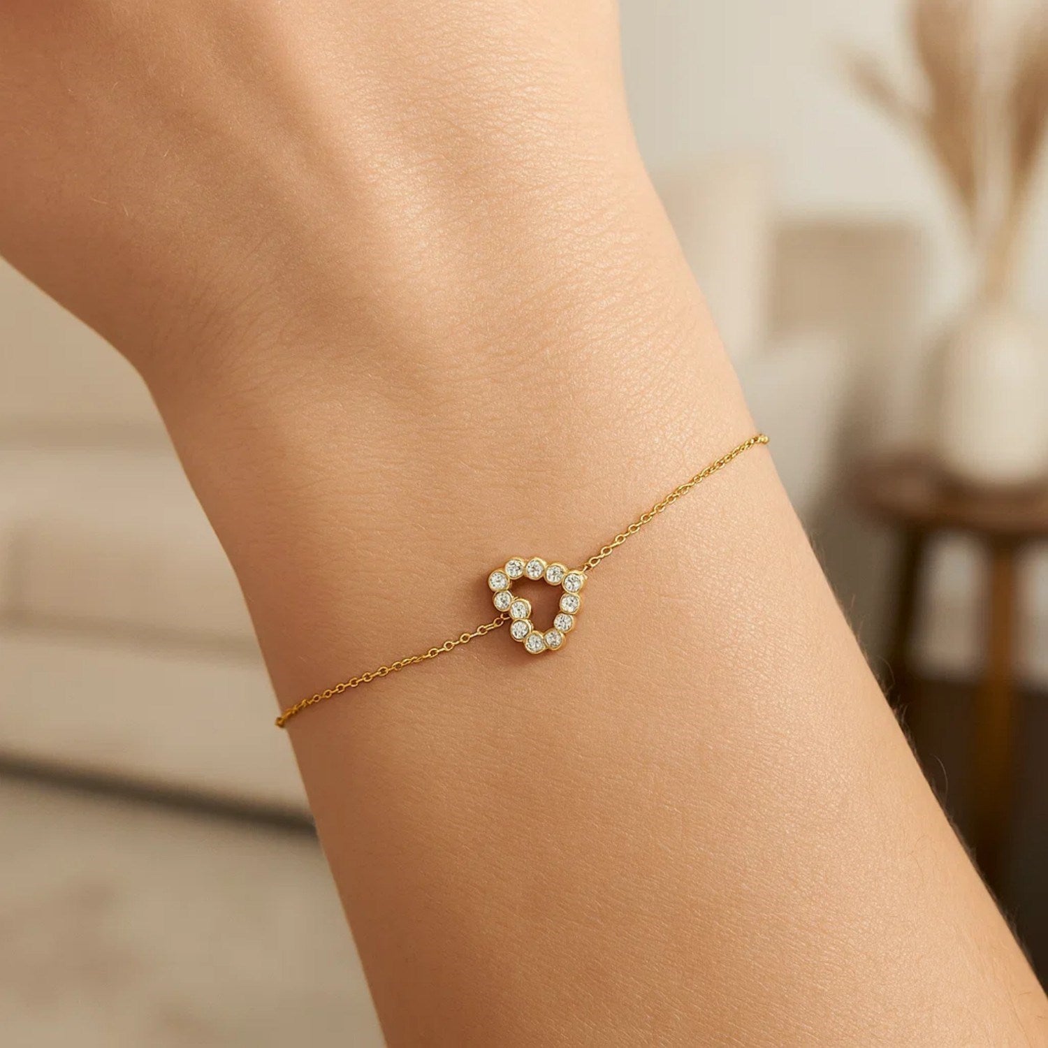 Elegant 14k yellow gold petite diamond heart bracelet on a person's wrist.