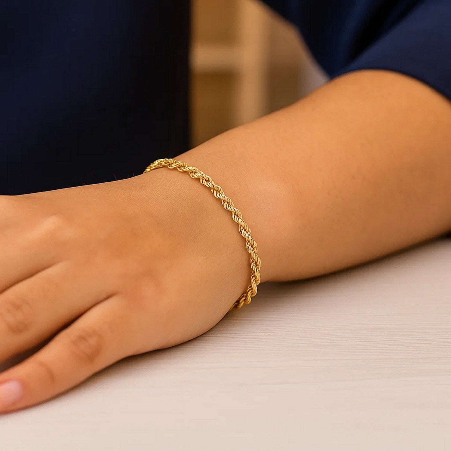 A 10k yellow gold lite rope chain bracelet on a person's wrist.