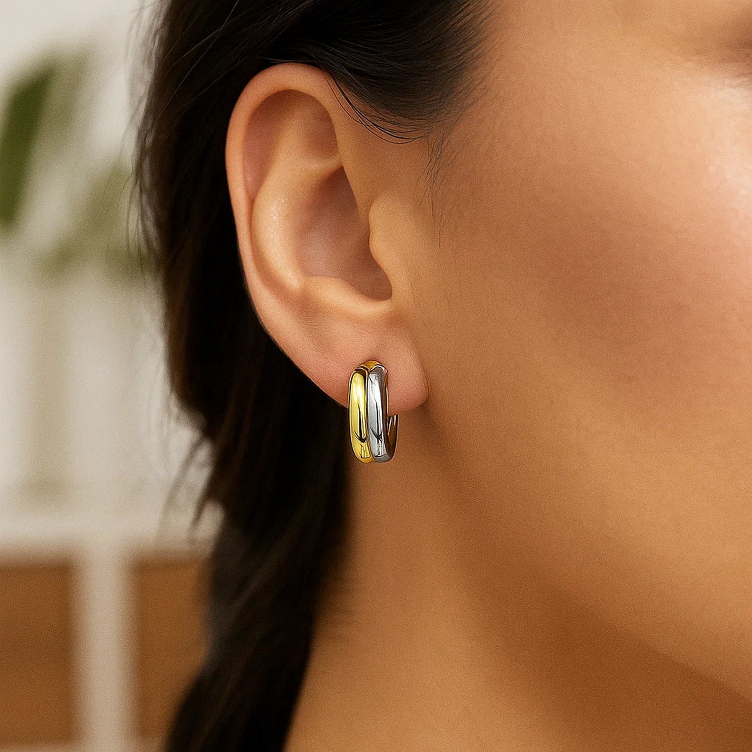 A woman wears 14k two-tone gold double round hoop earrings.