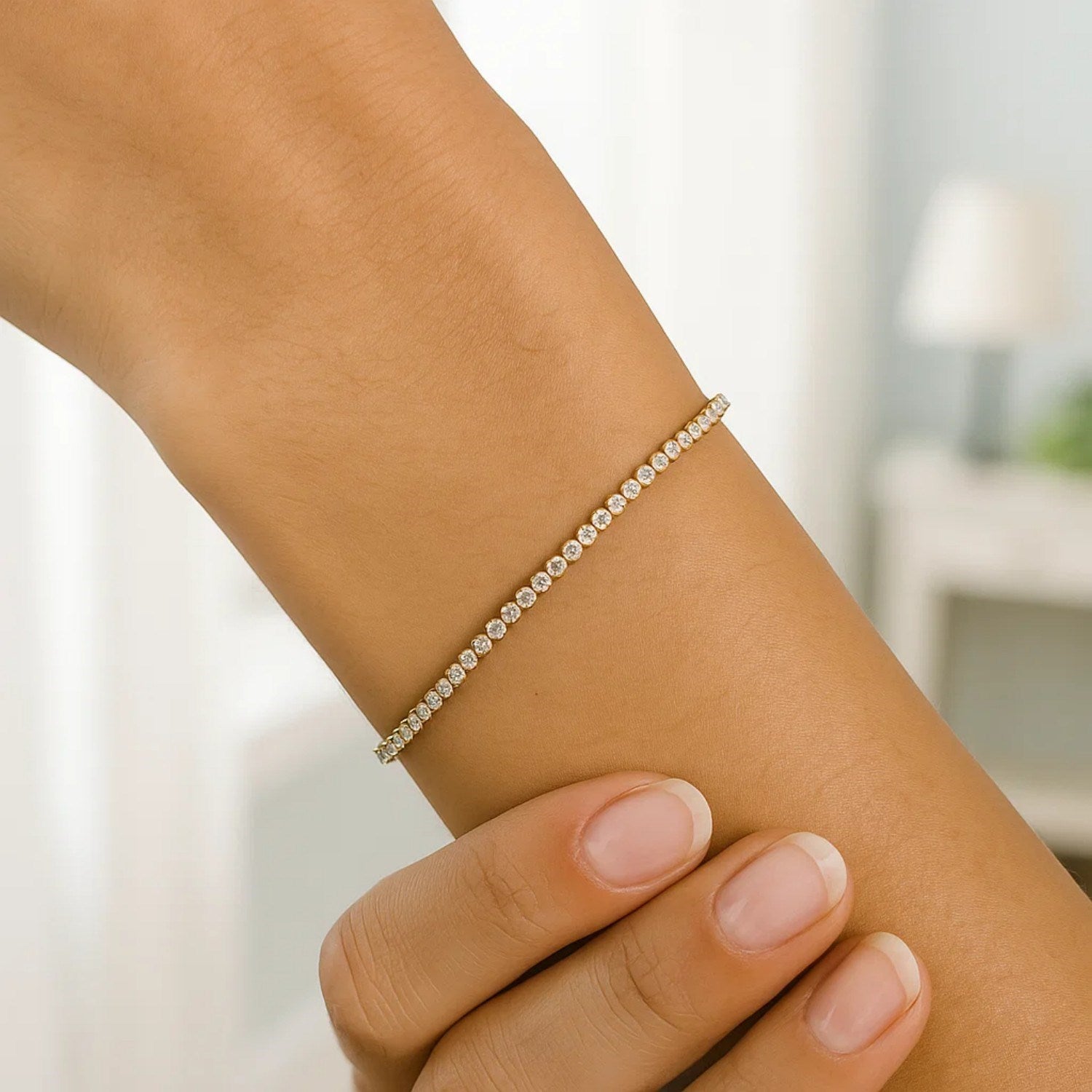 14K two-tone gold tennis bracelet with round diamonds on a woman's wrist.